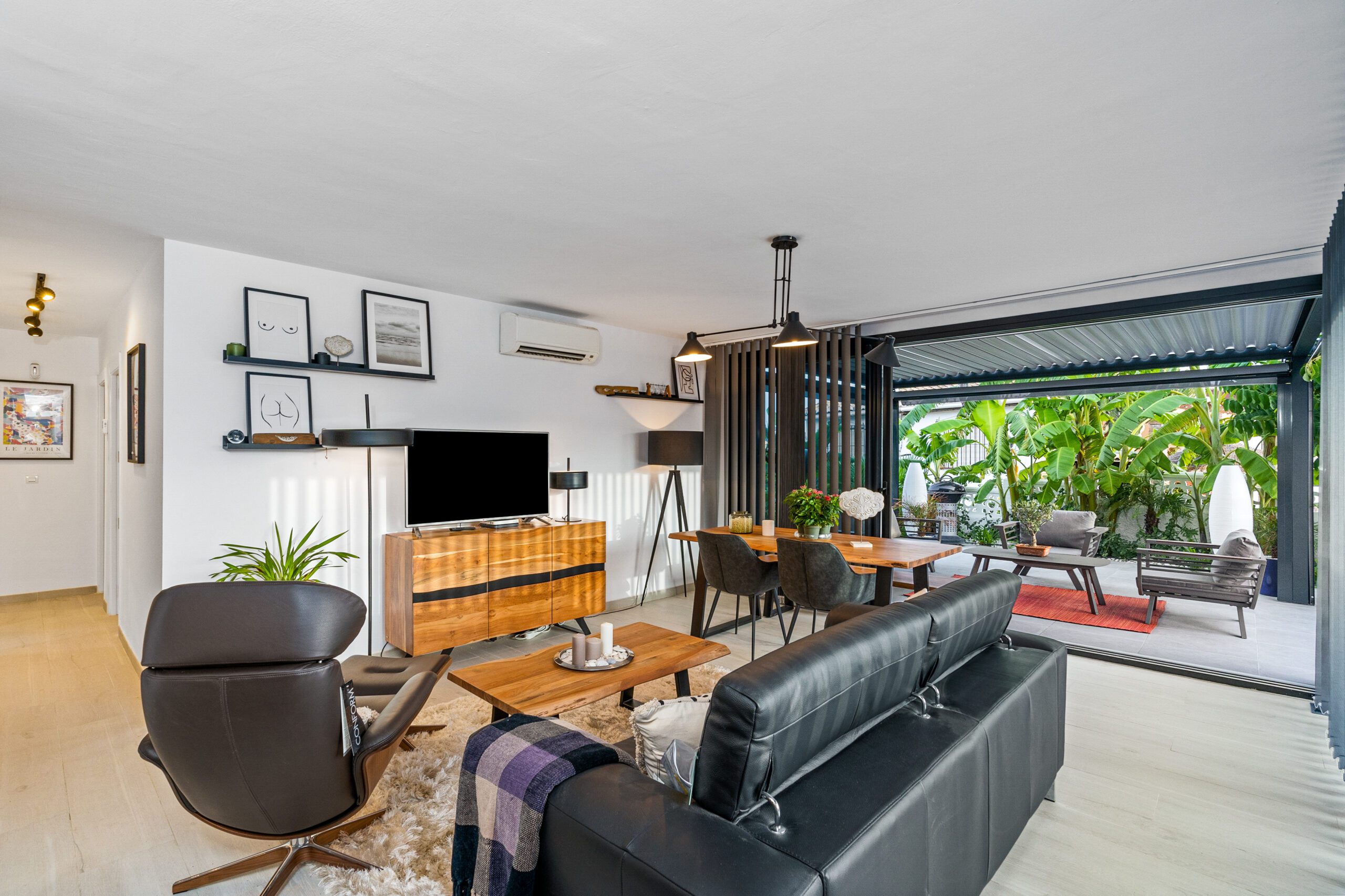 Chụp Ảnh Villa & Nhà Phố — Portfolio Dự Án Thực Tế | PES Studio 6 Phòng khách nhà phố ven sông với sofa da đen và cửa kính mở ra sân