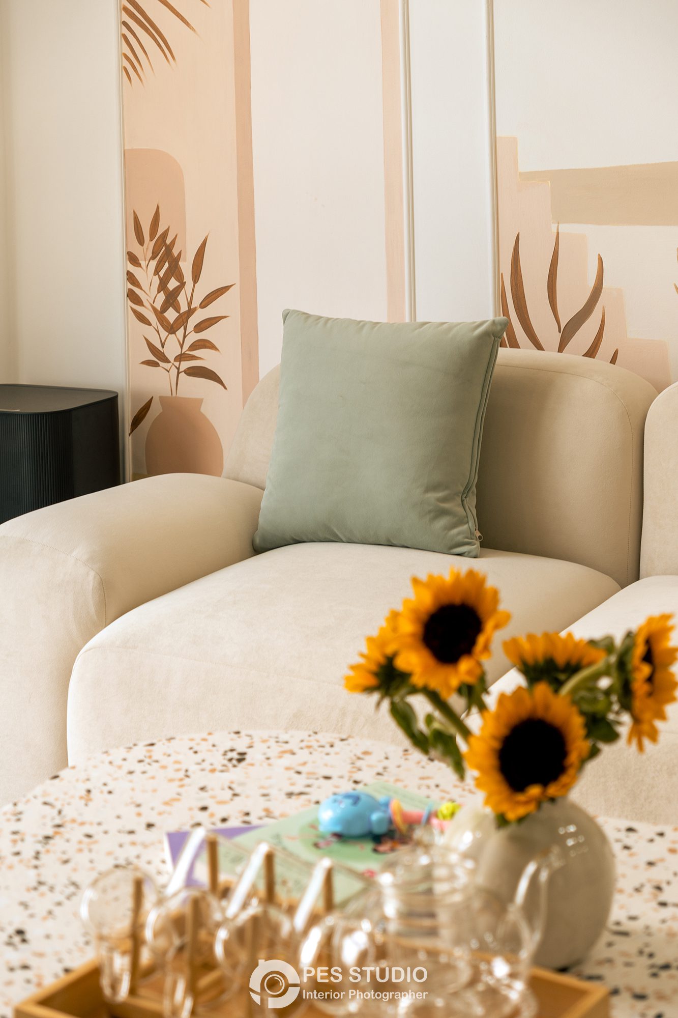 Cận cảnh sofa kem với gối xanh và hoa hướng dương