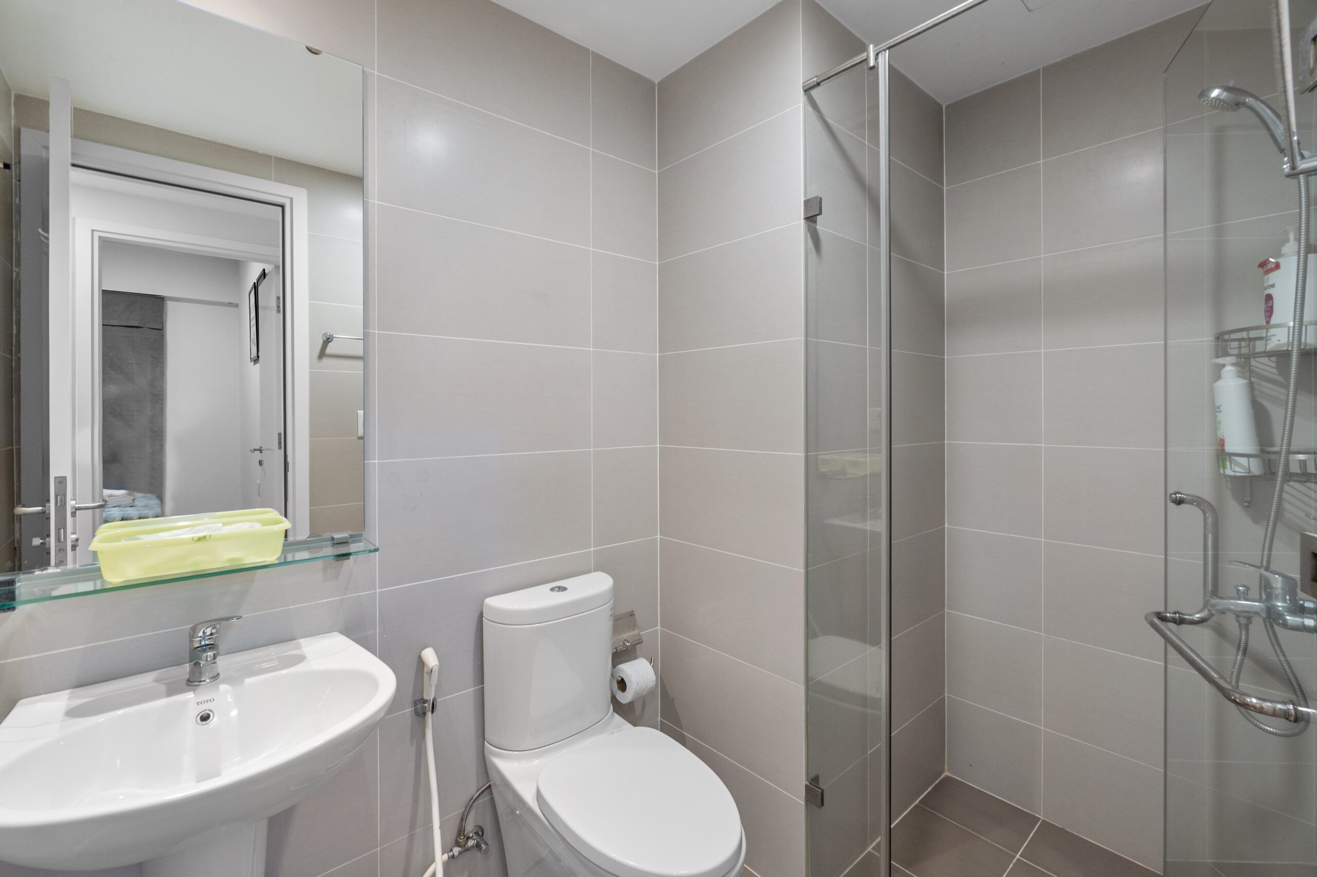 Phòng tắm căn hộ Masteri Thảo Điền với lavabo treo và buồng sen kính