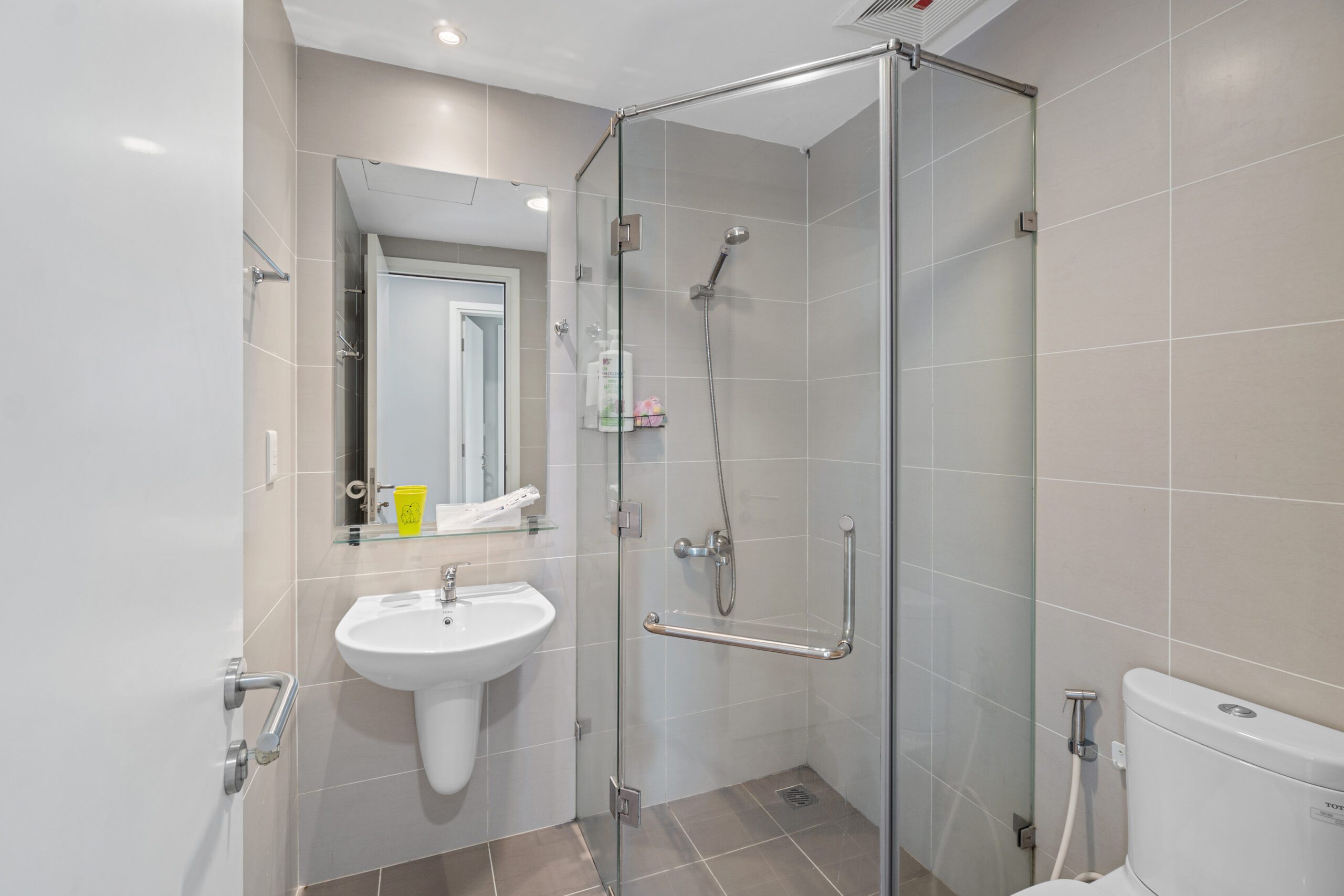 Phòng tắm căn hộ Masteri Thảo Điền với buồng sen kính và lavabo treo