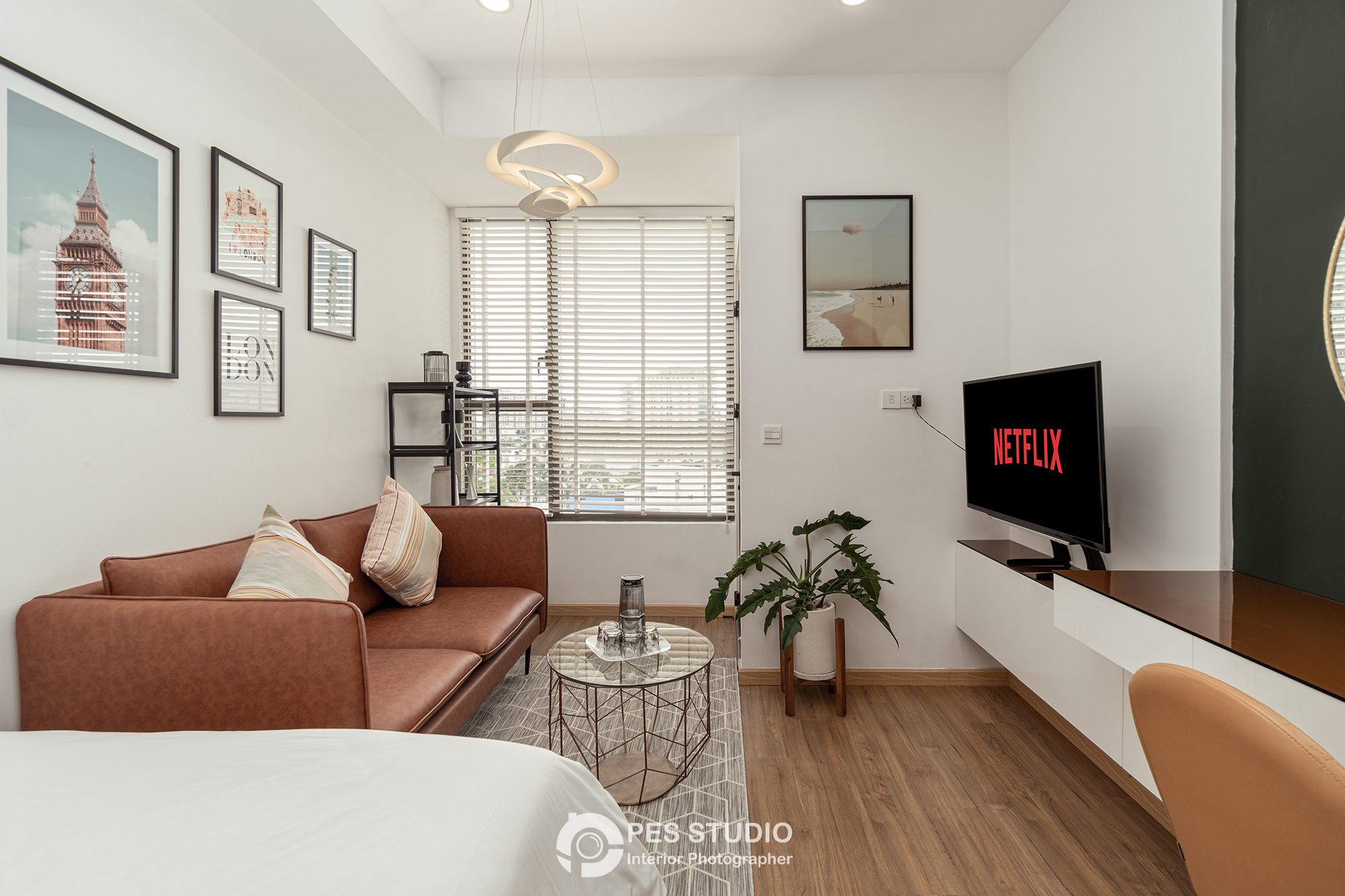 Sofa da nâu đối diện TV treo tường trong căn hộ River Gate