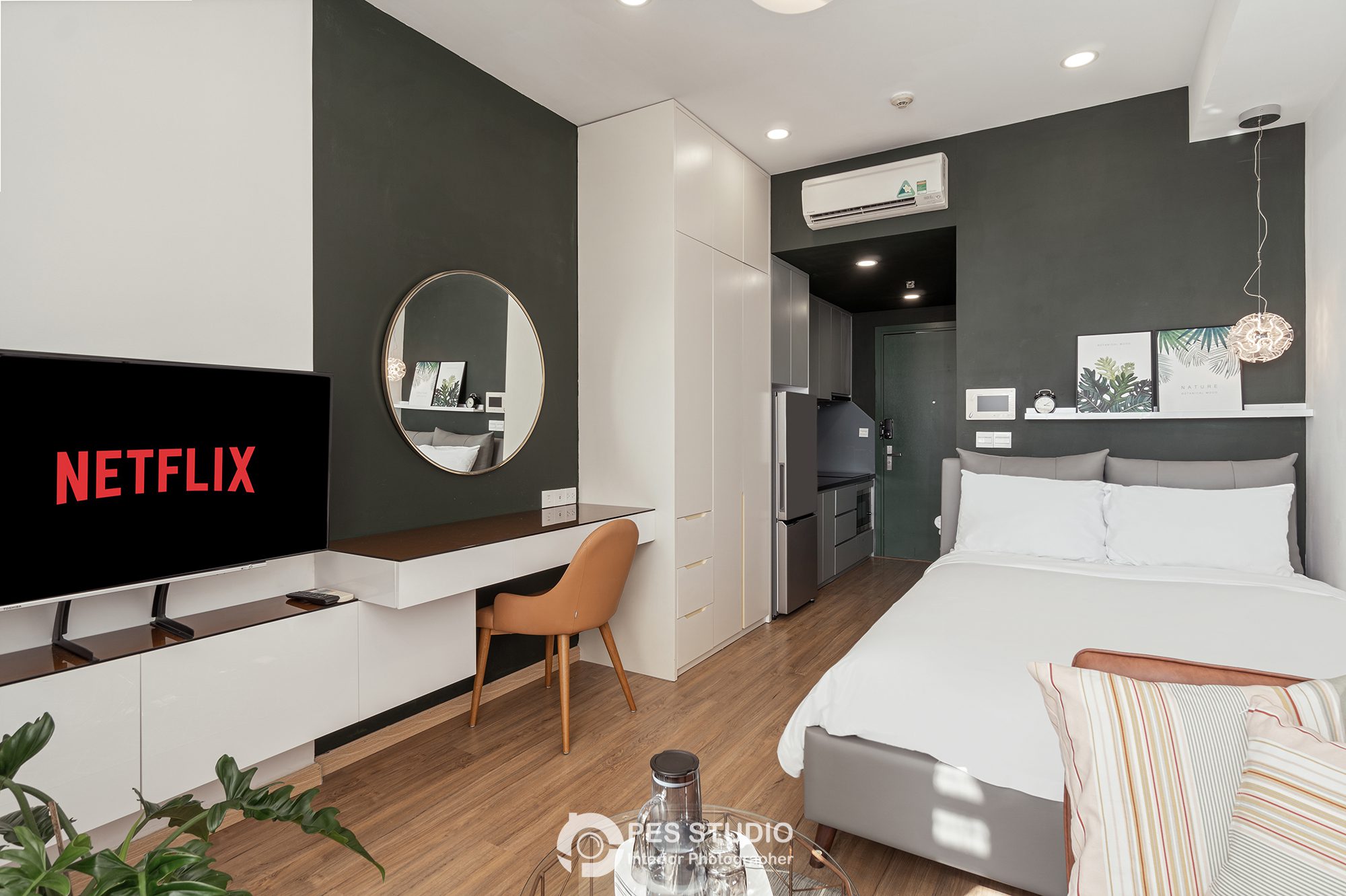 Studio River Gate với giường trắng, TV và bếp nhỏ phía sau