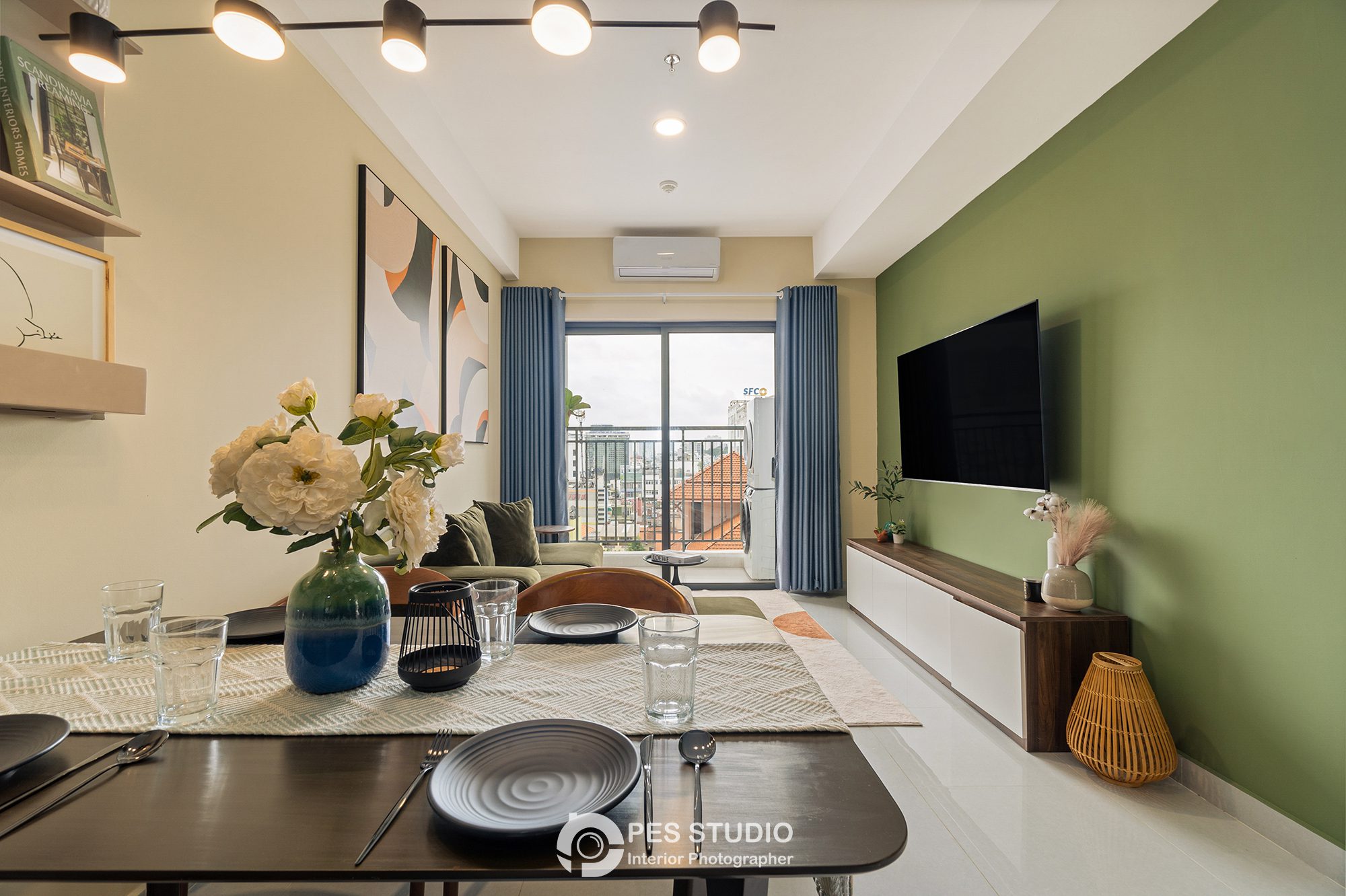 Bàn ăn tròn căn hộ Soho Residence với bình hoa và TV phía sau