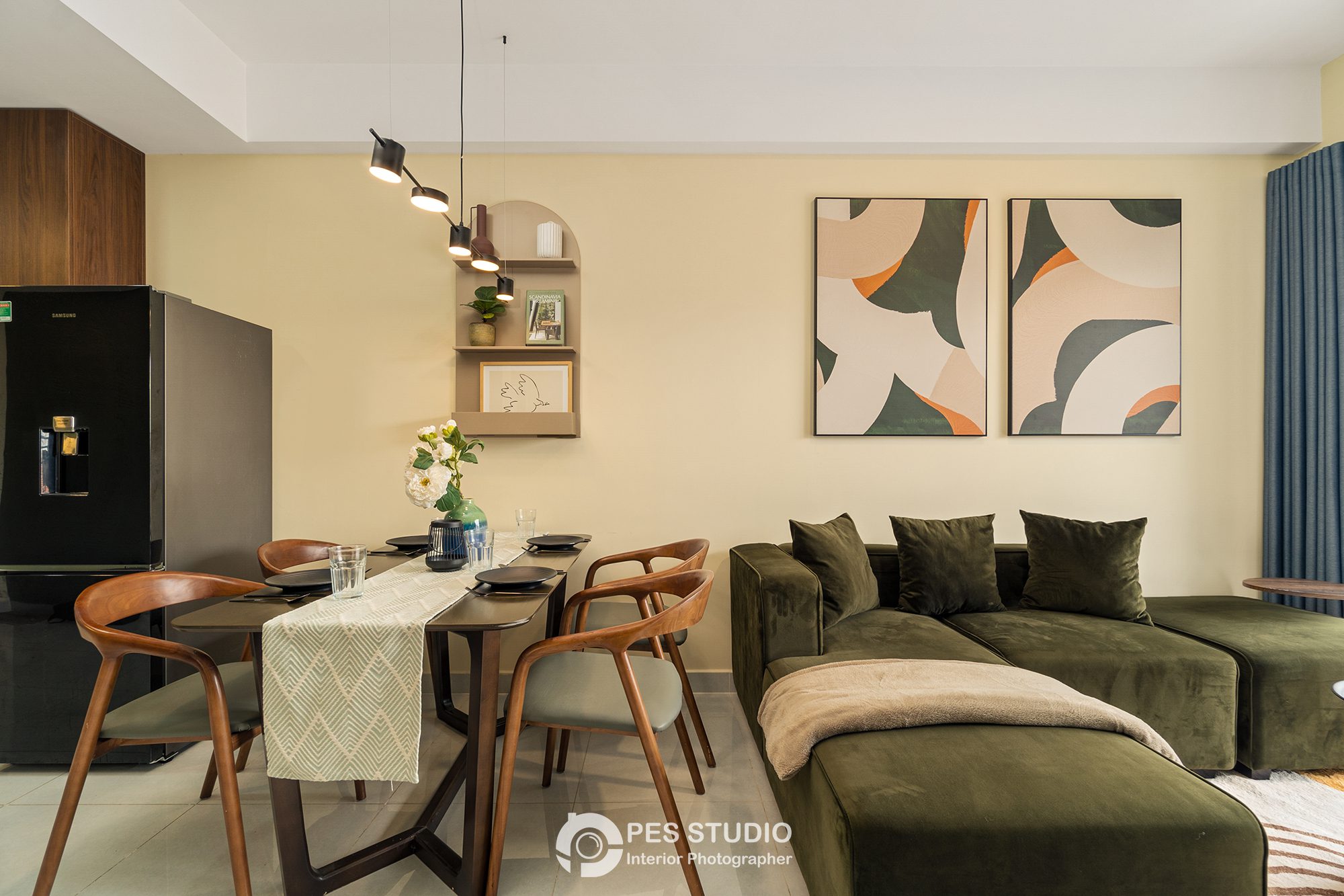 Bàn ăn và sofa xanh rêu trong căn hộ Soho Residence