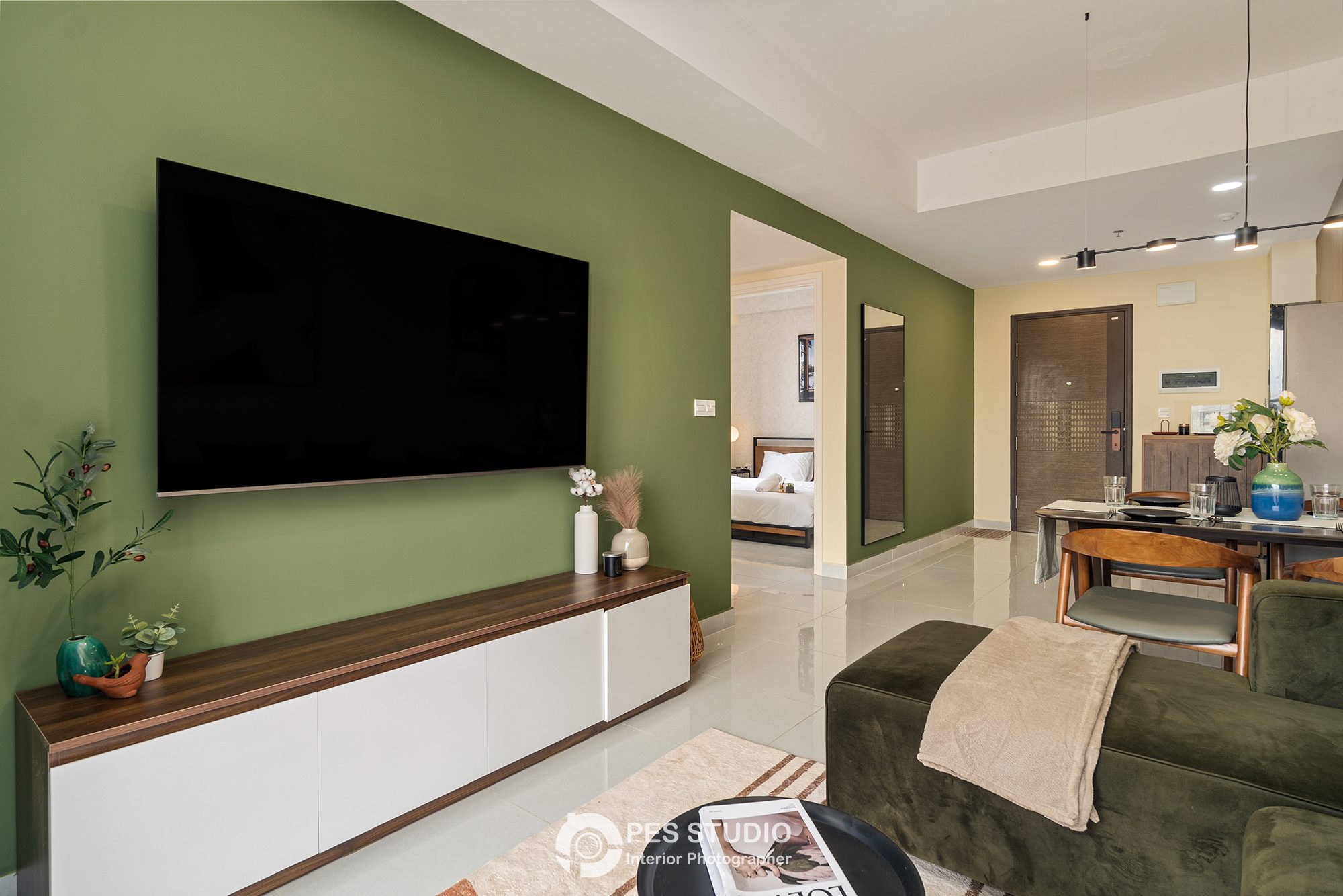 Phòng khách căn hộ Soho Residence với TV treo trên vách xanh rêu