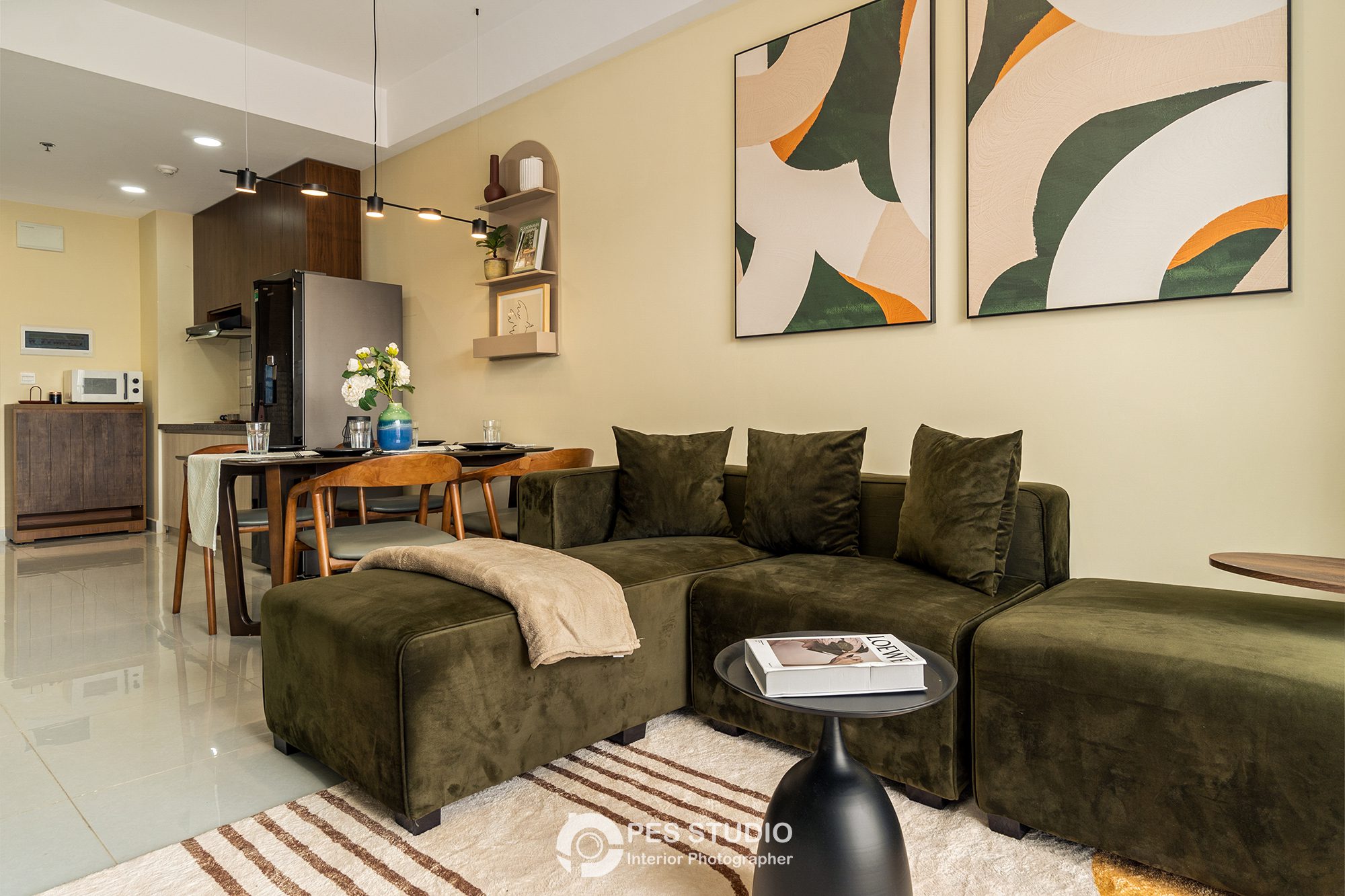 Phòng khách Soho Residence với sofa xanh rêu và tranh trừu tượng