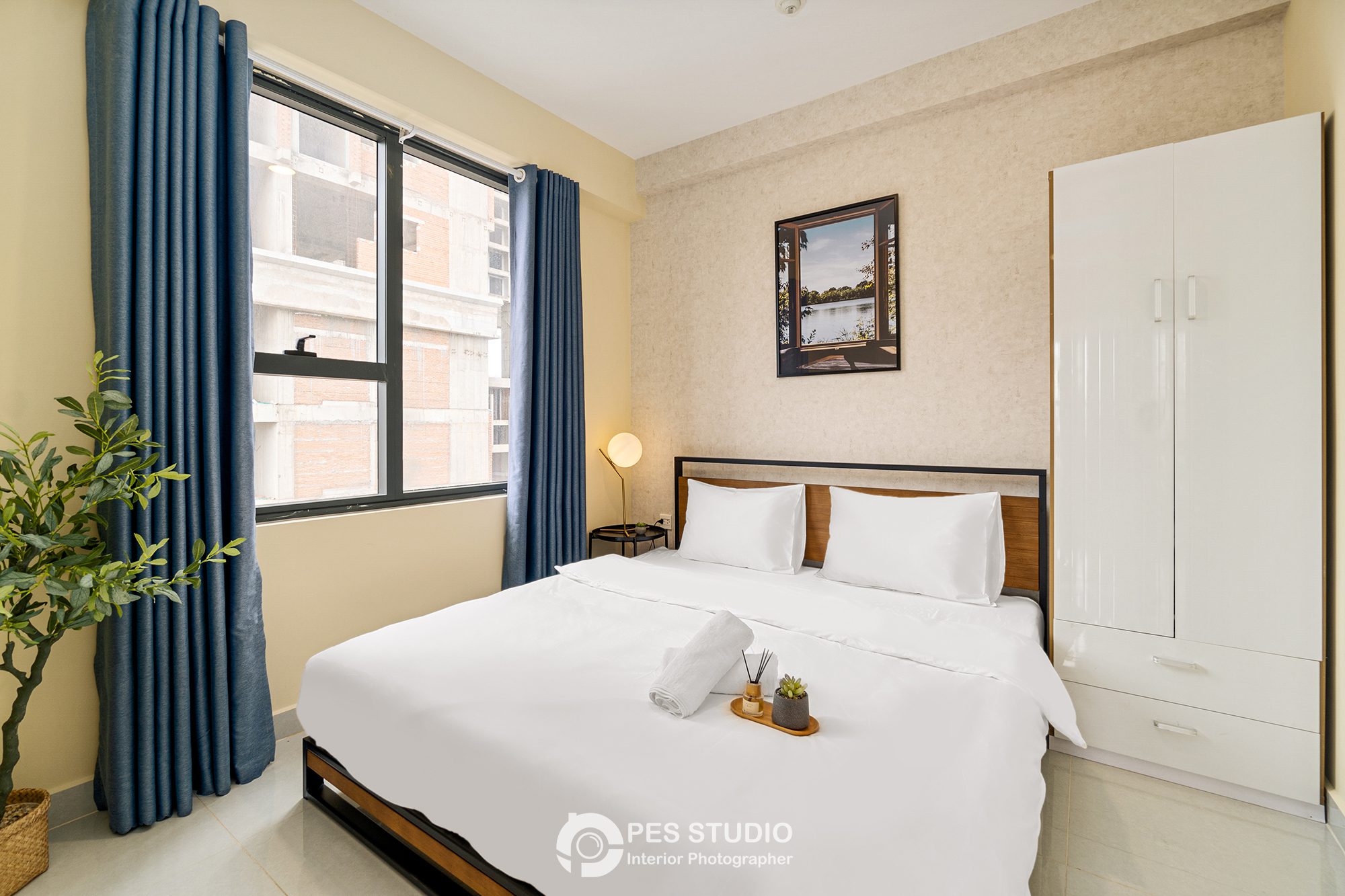 Phòng ngủ Soho Residence với giường trắng và cây xanh cạnh cửa sổ