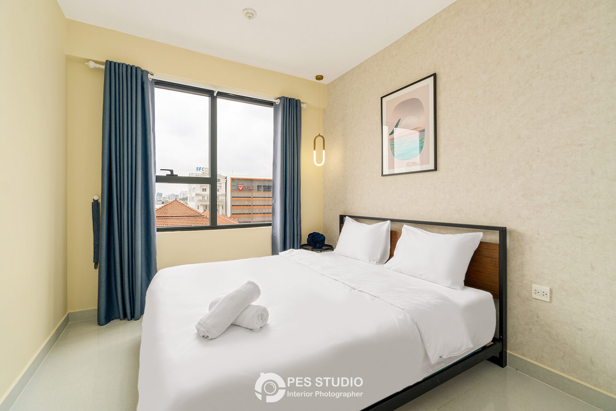 Phòng ngủ Soho Residence với rèm xanh và khăn gấp trên ga trắng