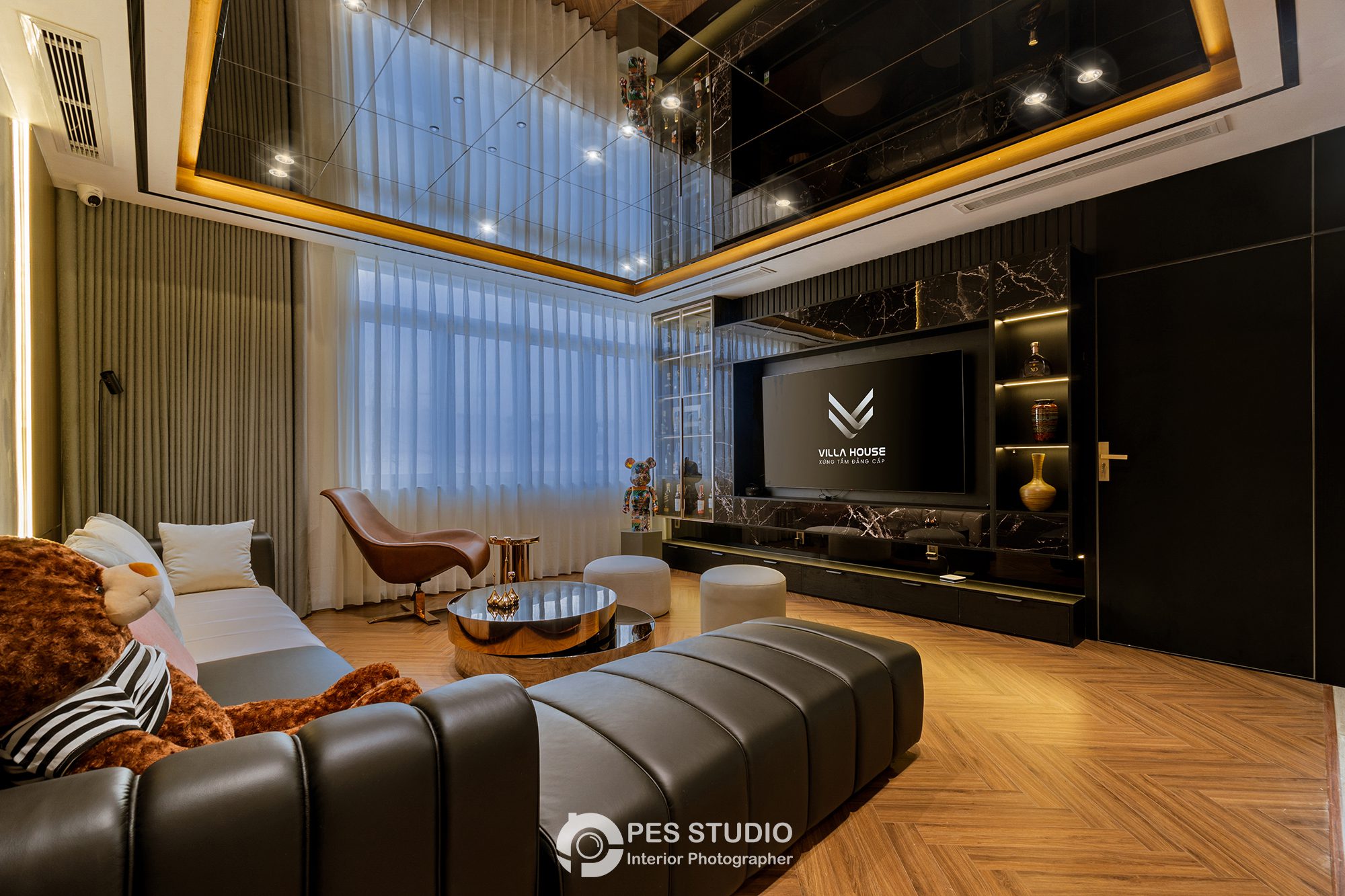 Phòng ngủ biệt thự Bình Dương với vách TV ốp gỗ và đèn hắt