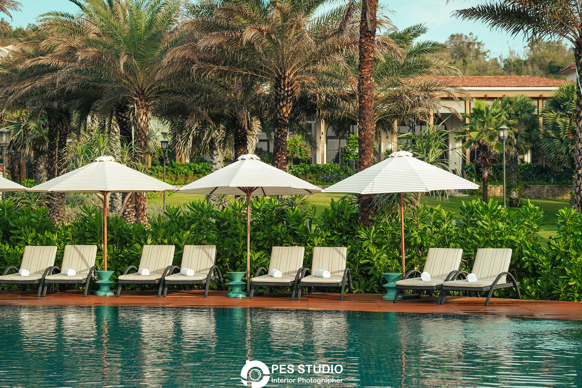 Dãy dù và ghế nằm chạy dọc hồ bơi resort Radisson