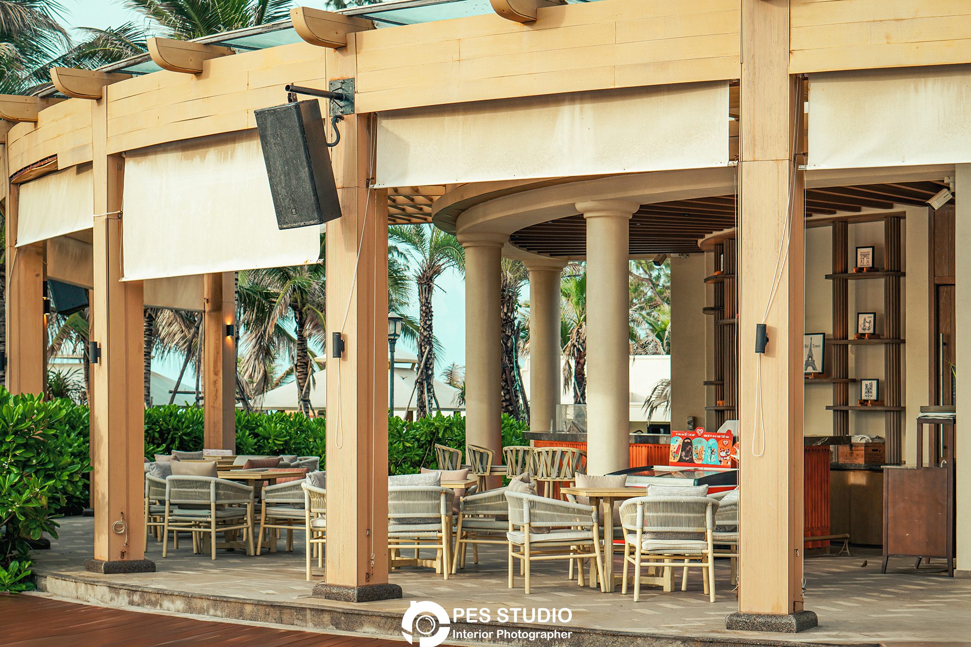 Nhà hàng ngoài trời resort Radisson với hàng cột và bàn ghế mây
