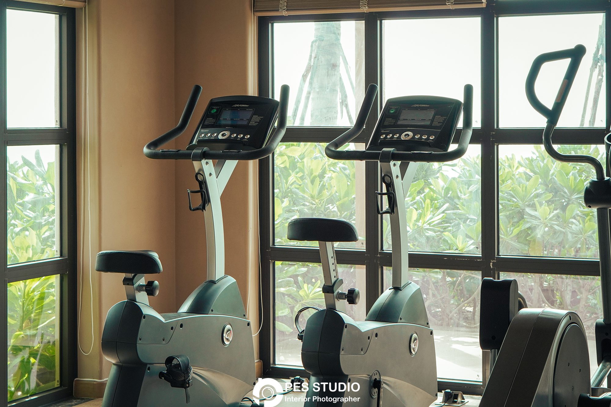 Phòng gym resort Radisson với dàn xe đạp tập trước cửa kính