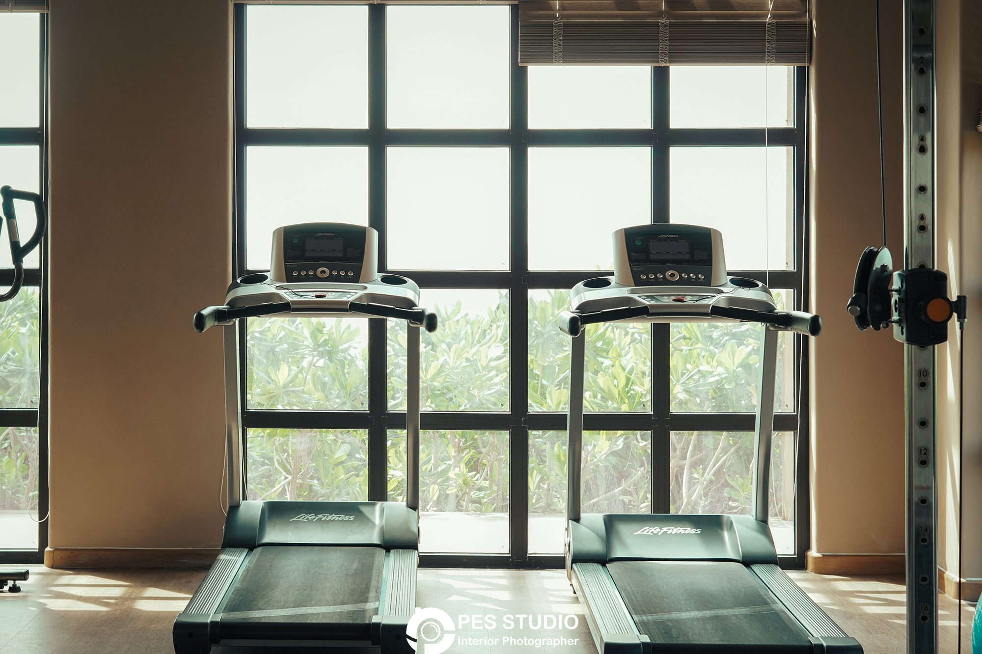 Phòng gym resort với máy chạy bộ nhìn ra vườn