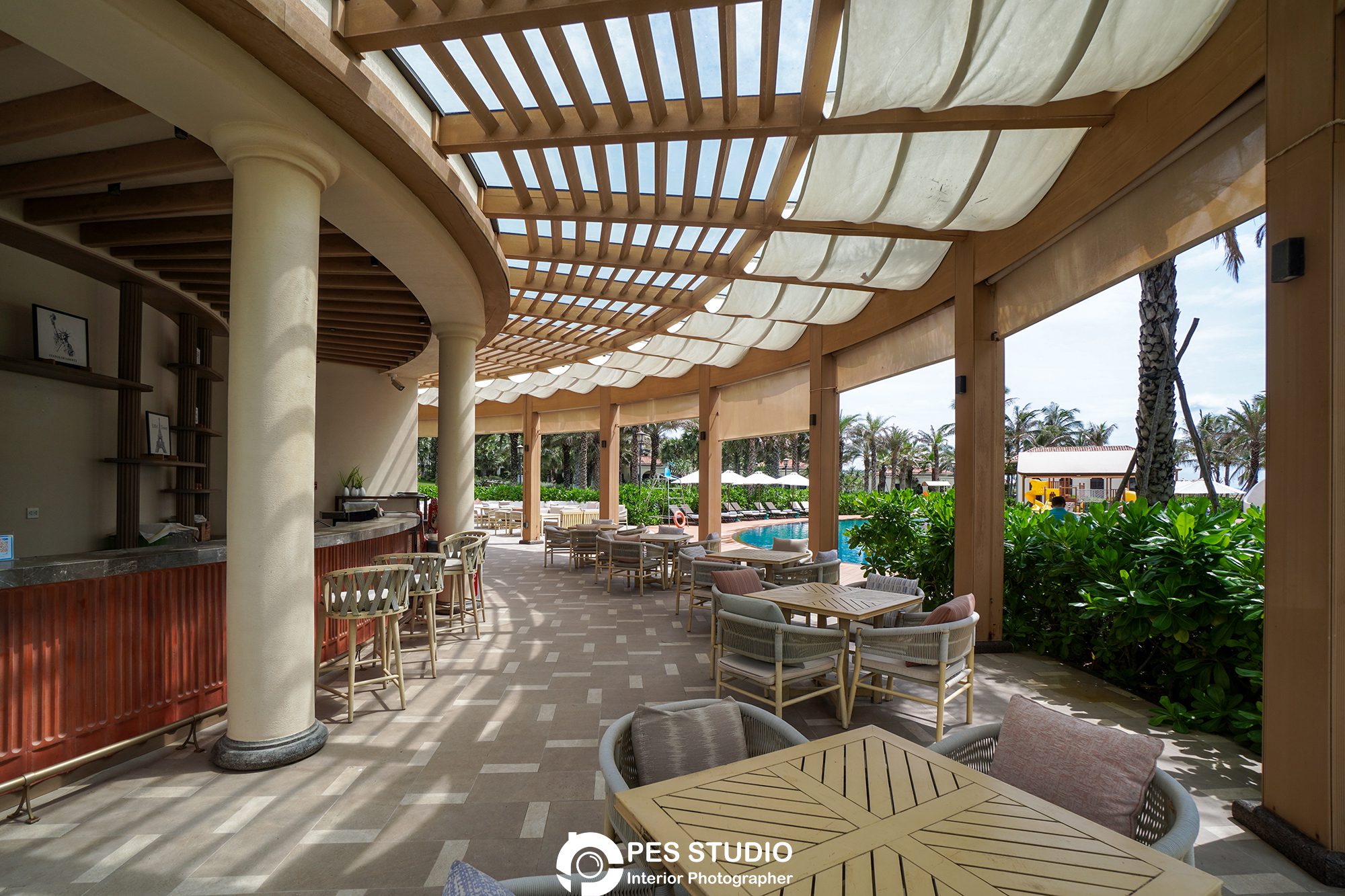 Lối đi có giàn pergola gỗ dẫn từ resort ra bãi biển