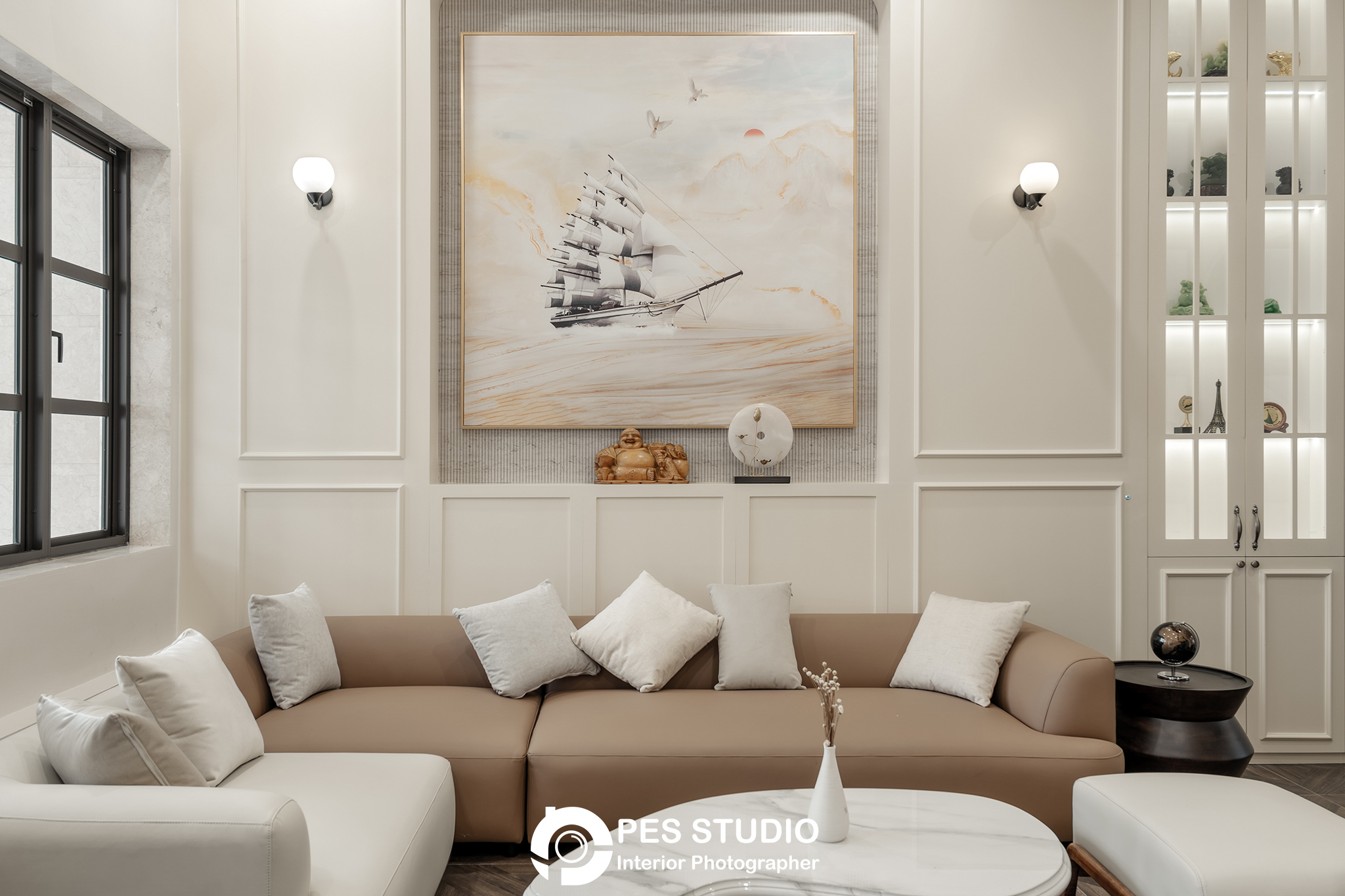 Sofa cong kem và tranh treo tường trong phòng khách nhà phố CityLand
