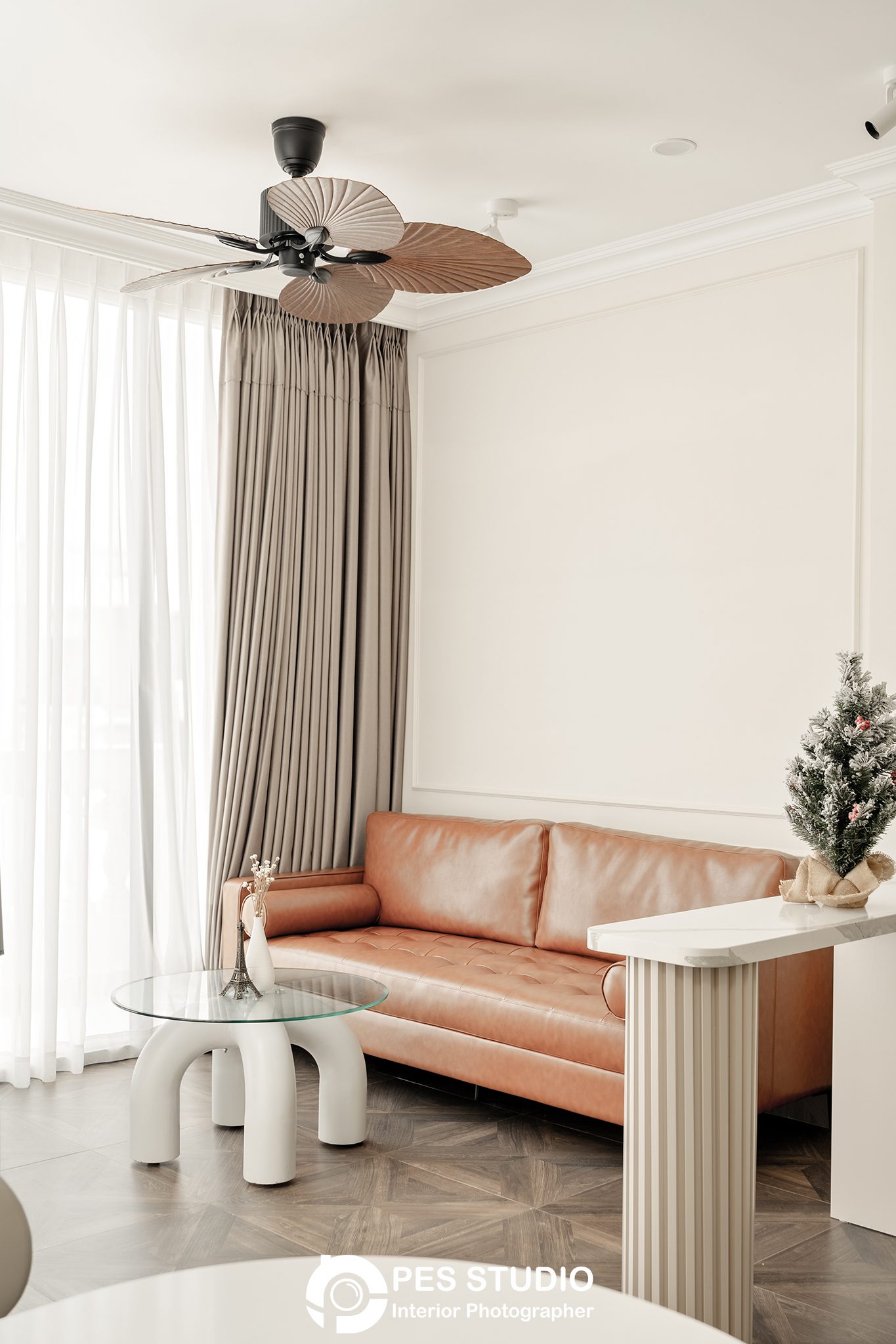 Ghế sofa da nâu và cây thông trang trí trong nhà phố CityLand