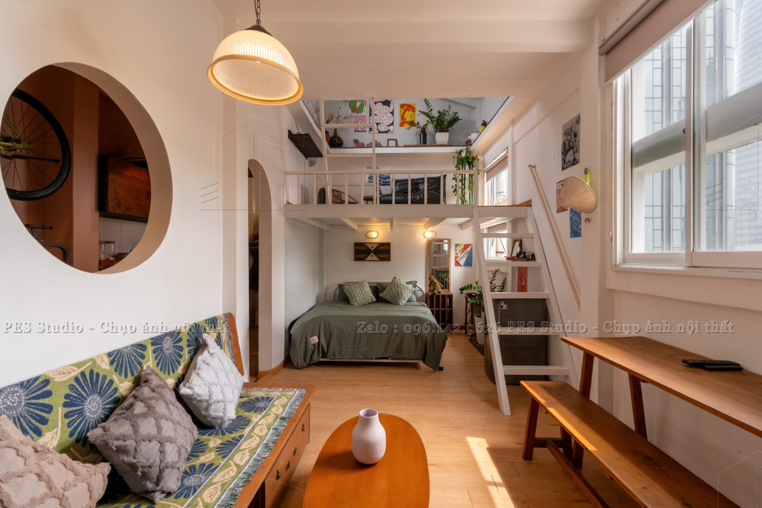 Phòng khách homestay Nguyễn Huệ với sofa vải hoa và kệ sách