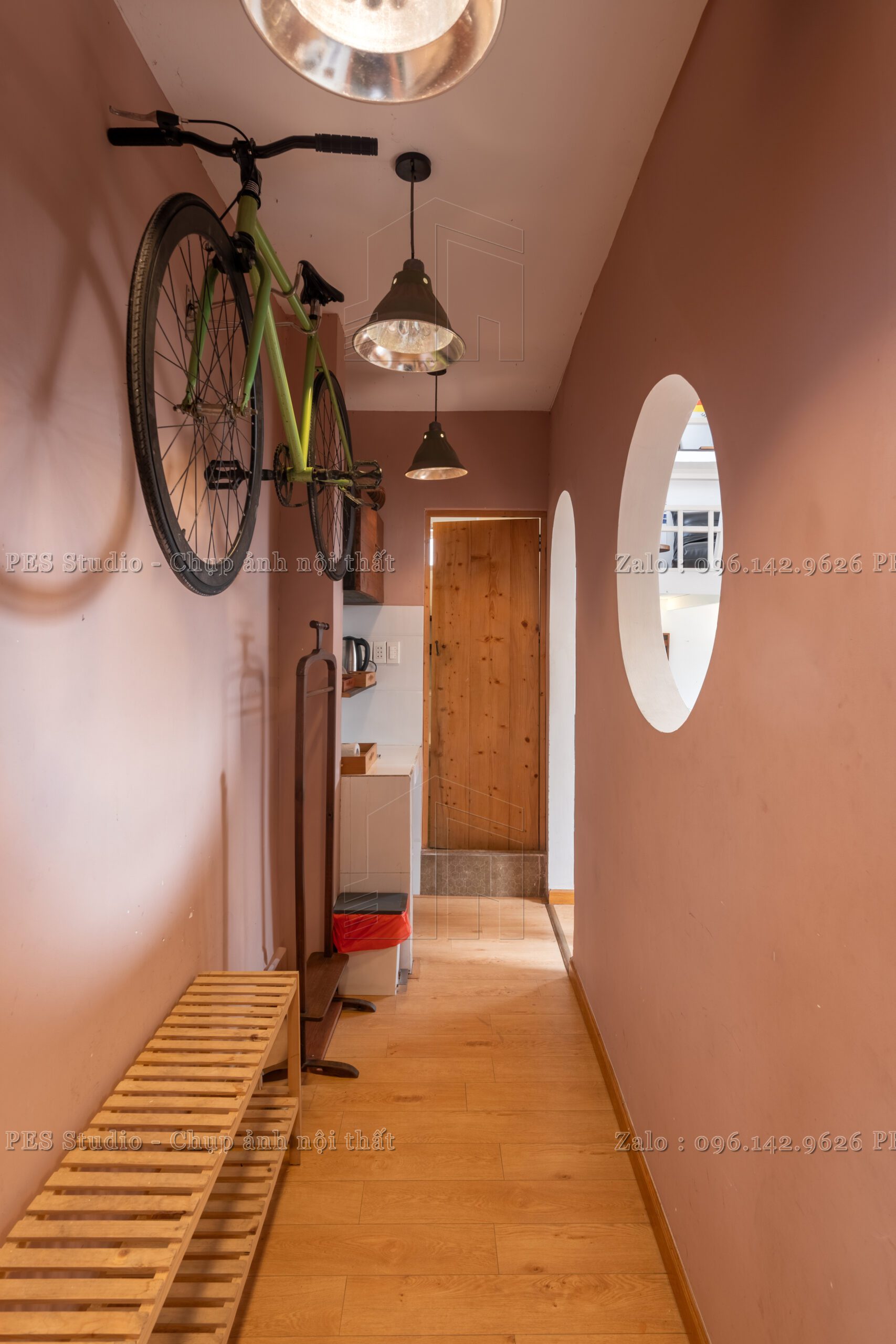 Gương oval và cửa gỗ trong homestay chung cư 42 Nguyễn Huệ
