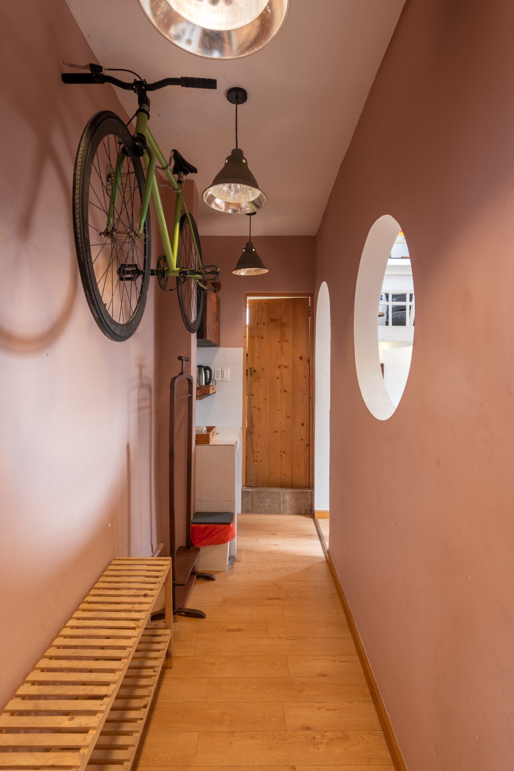 Góc bếp homestay chung cư Nguyễn Huệ với gương oval và xe đạp treo