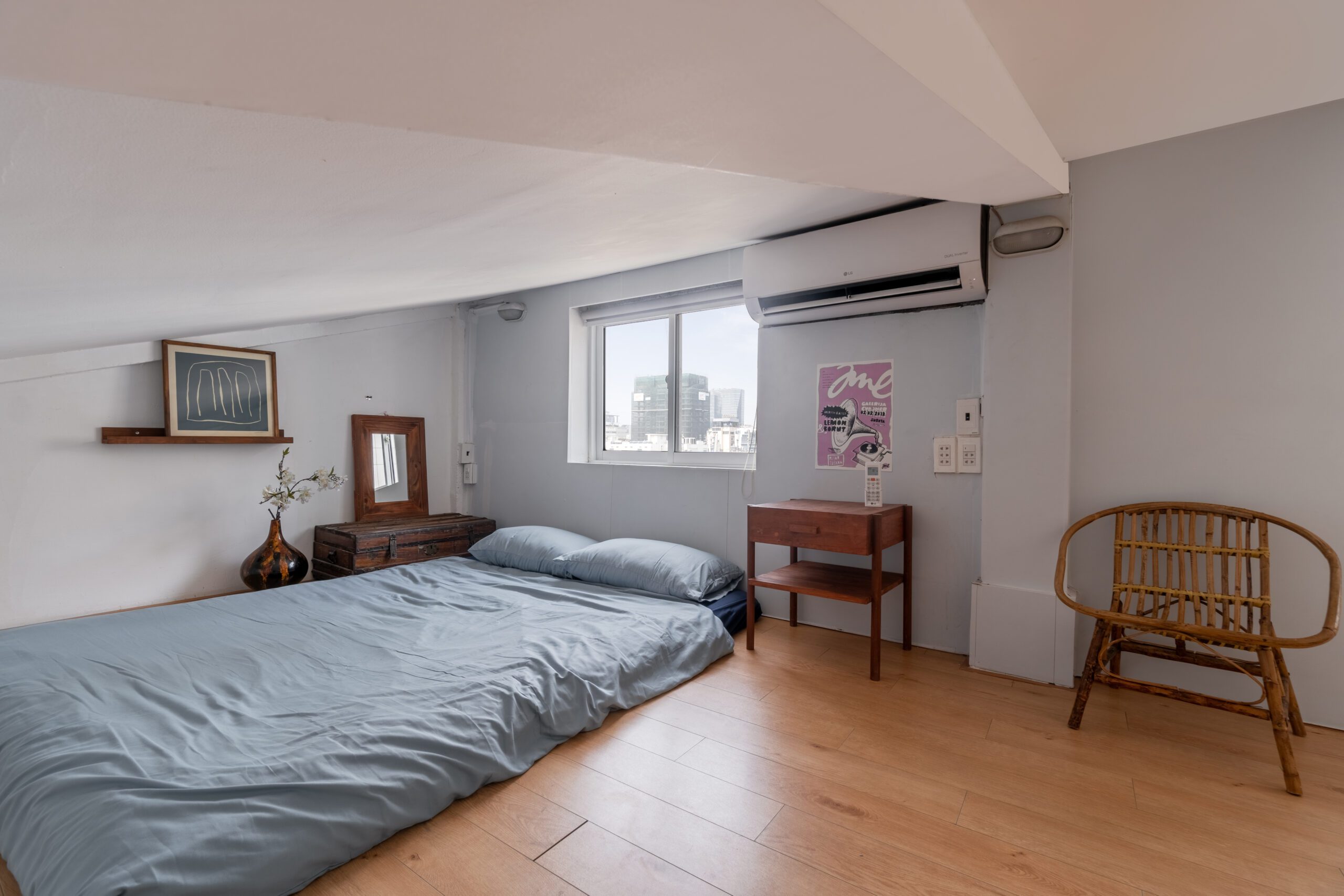 Phòng ngủ homestay với ghế mây, bàn nhỏ và cửa sổ lấy sáng