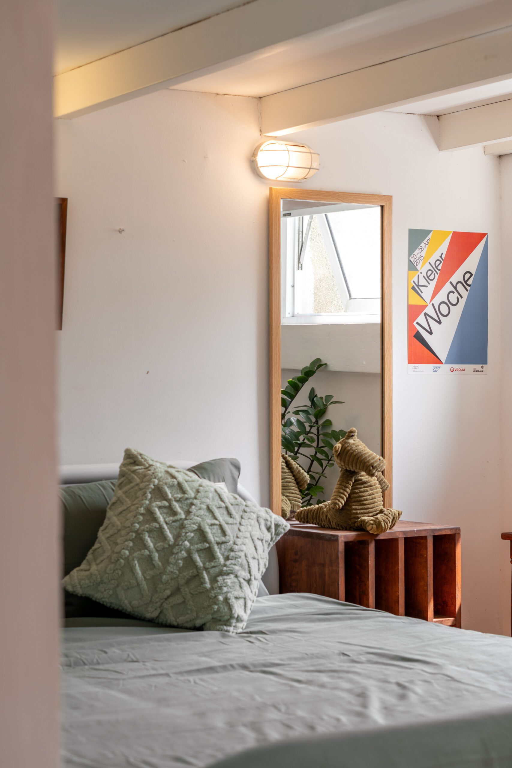 Góc trang trí homestay với poster, cây xanh và gối tựa