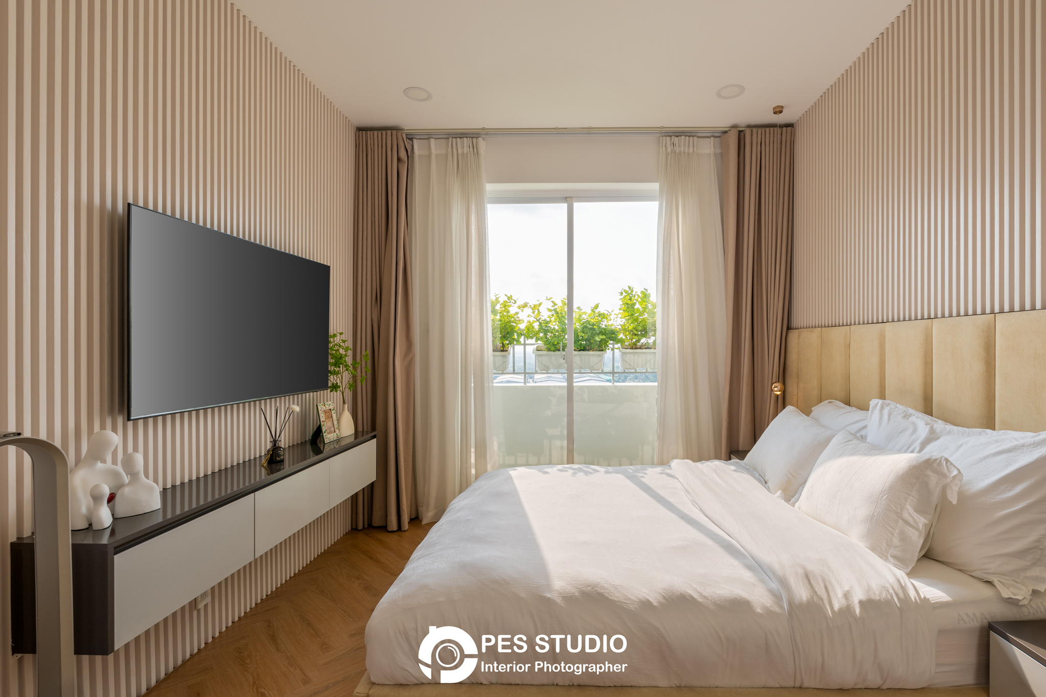 Phòng ngủ căn hộ Dream Palace với TV treo tường và cửa sổ lấy sáng