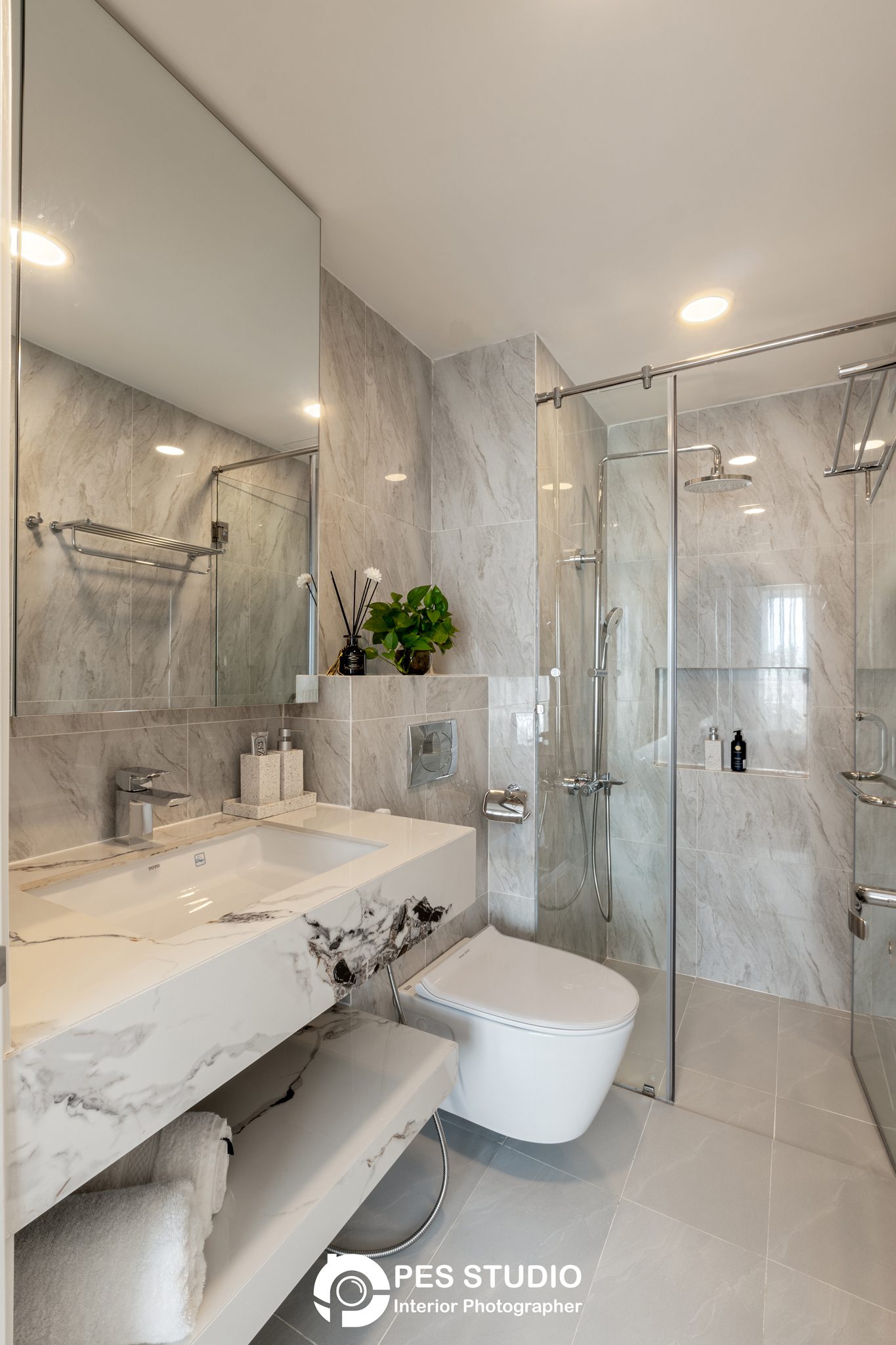 Buồng tắm kính và bàn lavabo ốp đá trong căn hộ Dream Palace