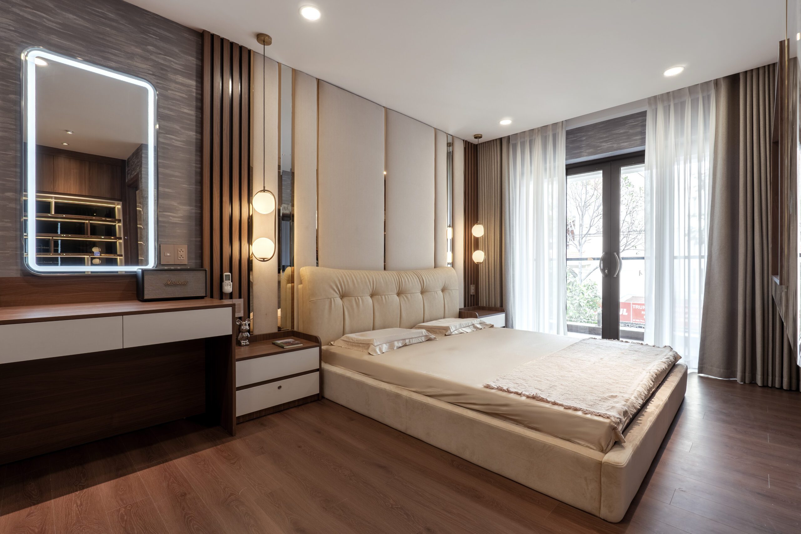 Phòng ngủ master nhà phố với đầu giường bọc và đèn thả hai bên