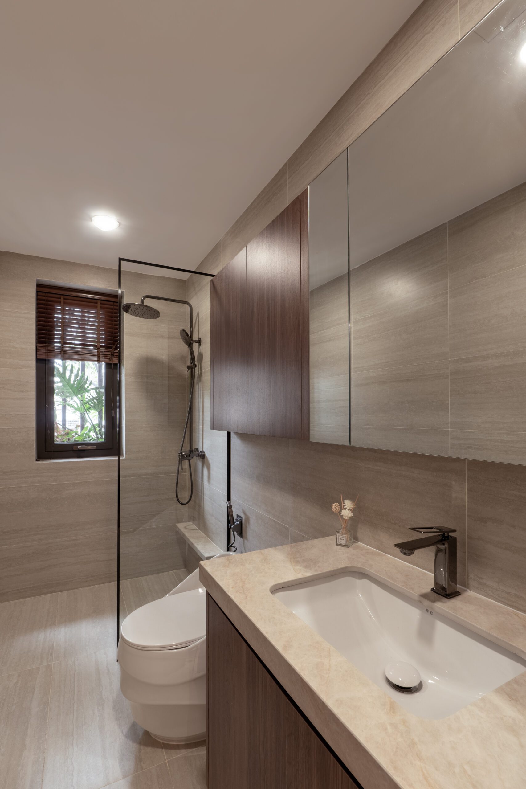 Buồng tắm kính và bàn lavabo ốp đá trong nhà phố Trần Phú