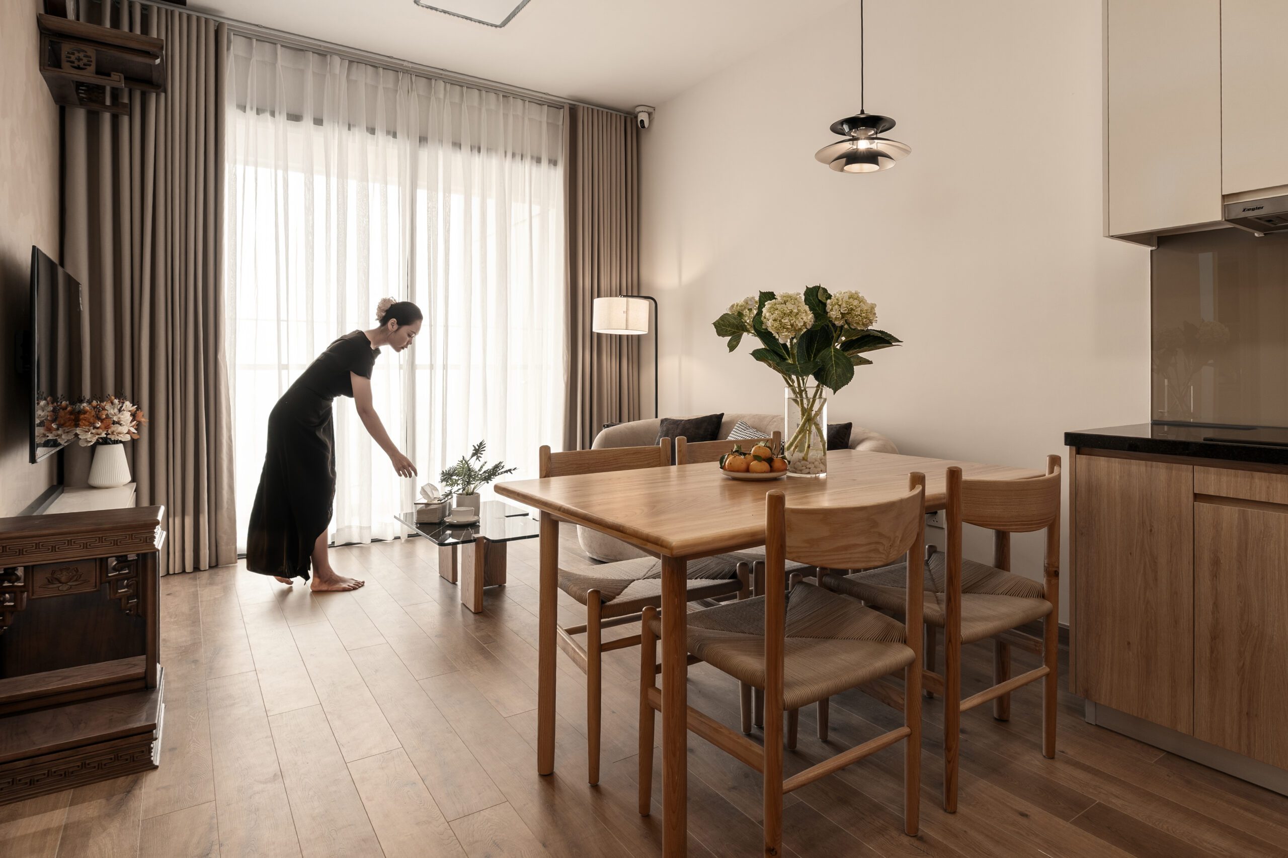 Bàn ăn căn hộ Akari City Nam Long với người đang set bàn