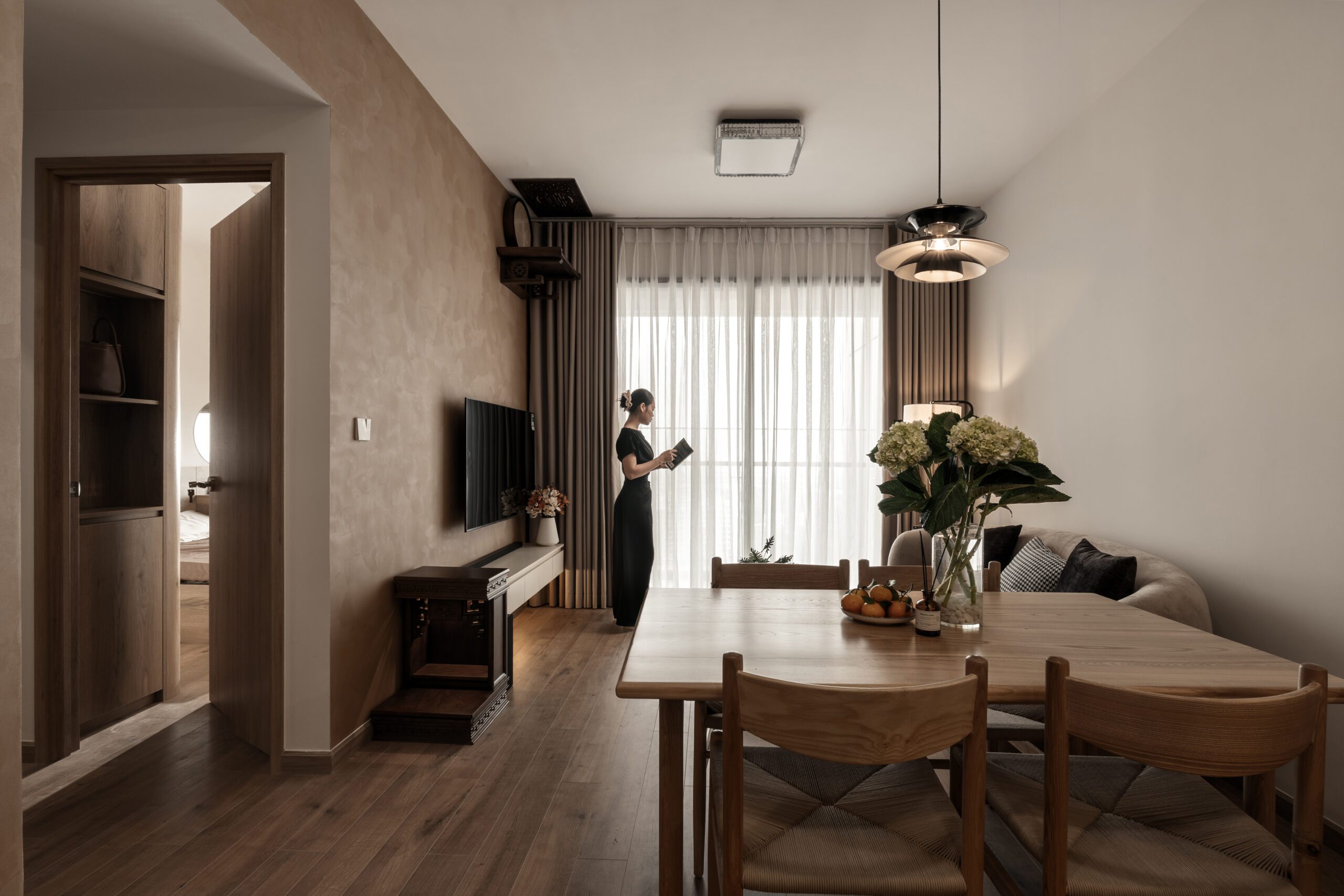 Phòng khách căn hộ Akari Nam Long nhìn từ hành lang với tủ TV gỗ