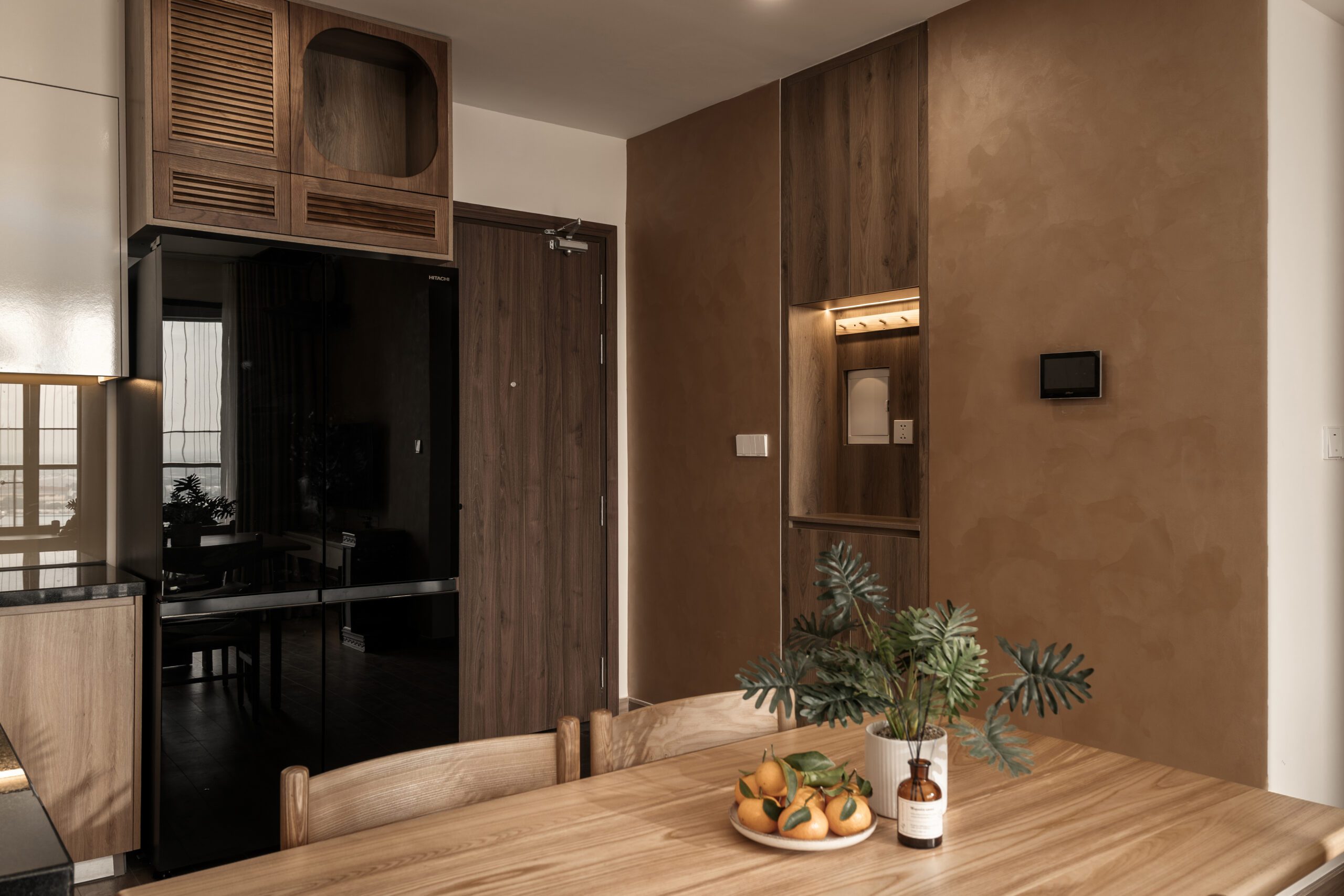 Bếp căn hộ Akari City Nam Long với tủ gỗ và tủ lạnh đen