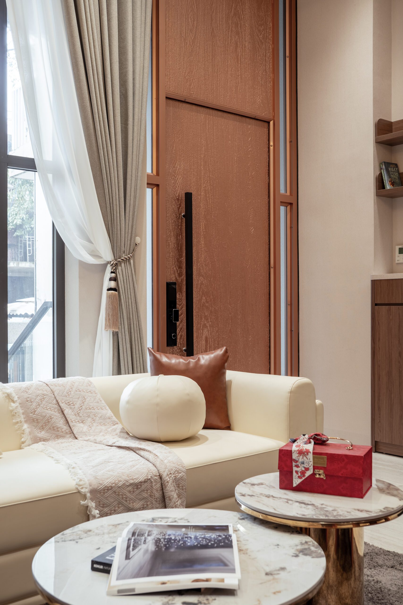 Ghế bành cam đặt cạnh cửa sổ rèm voan trong nhà phố