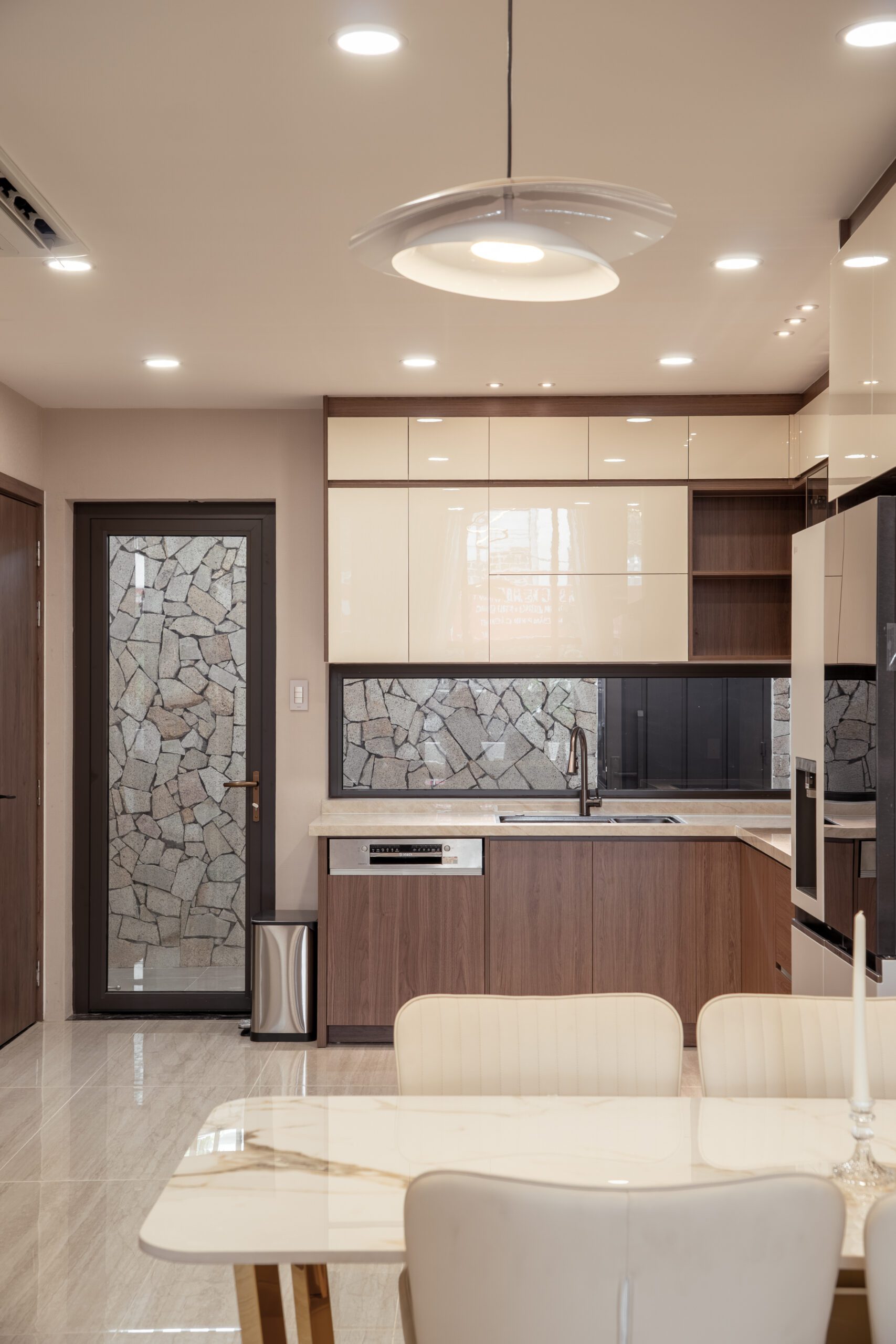 Bếp nhà phố với mặt đá vân và tủ trên kính đen