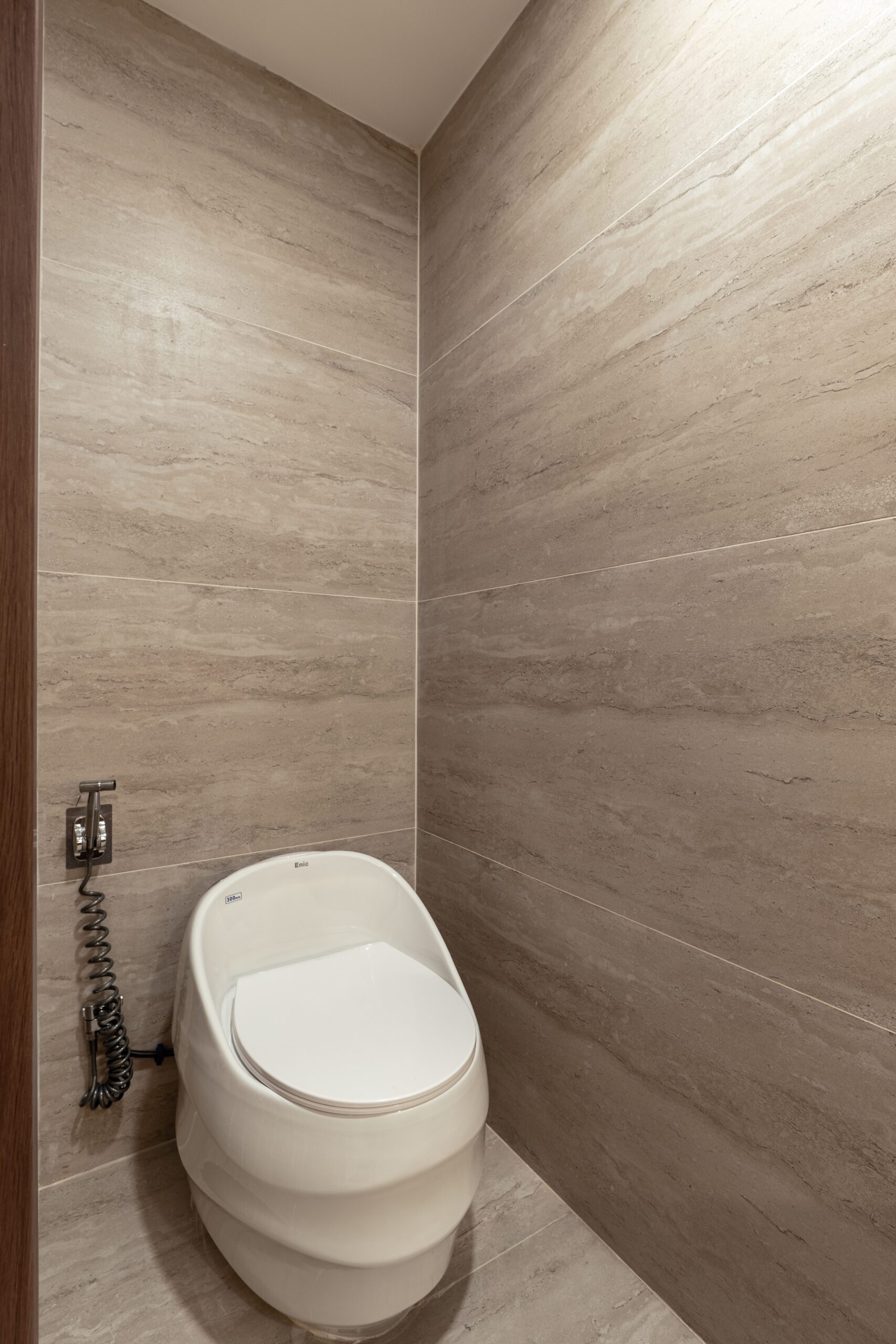 Phòng tắm nhà phố với bồn cầu treo và tường ốp đá vân