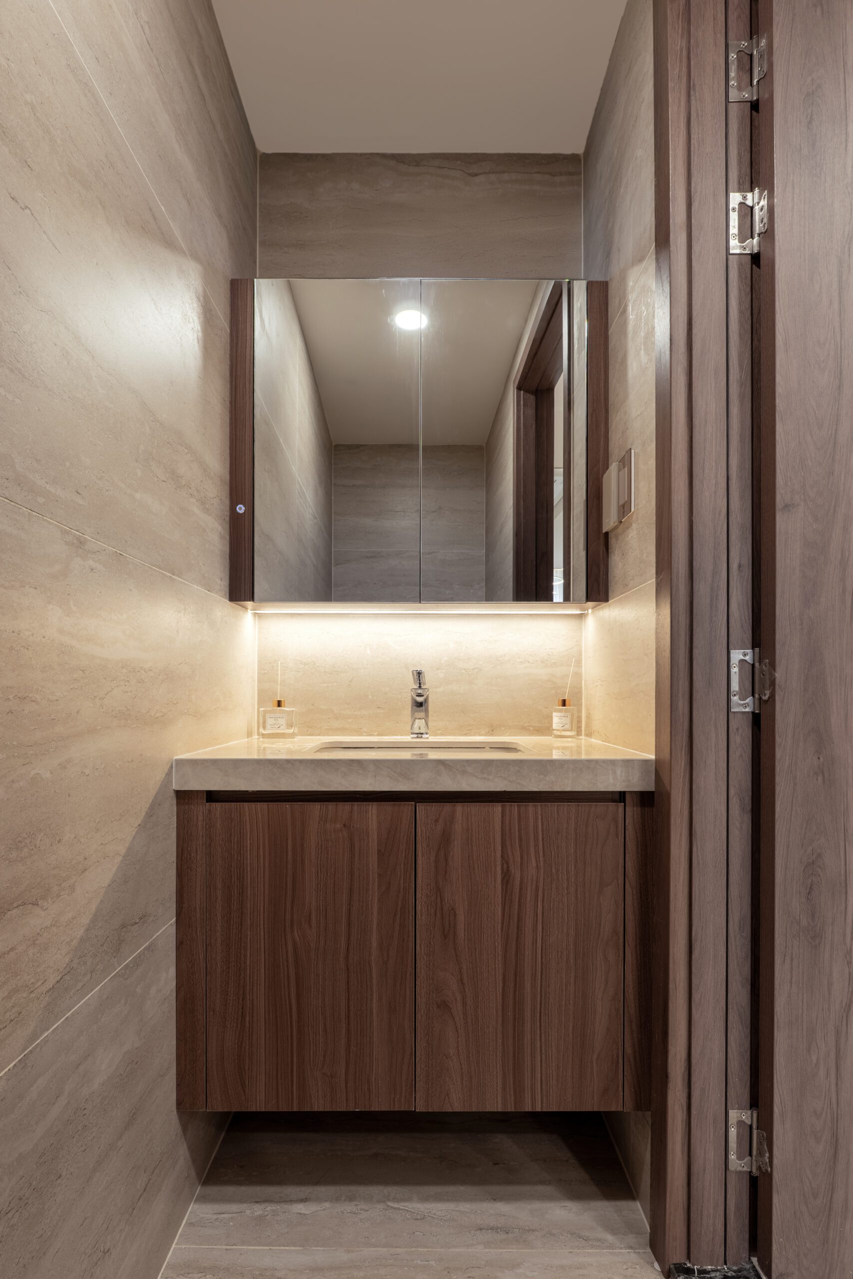 Bàn lavabo ốp đá với gương dài viền đèn trong nhà phố