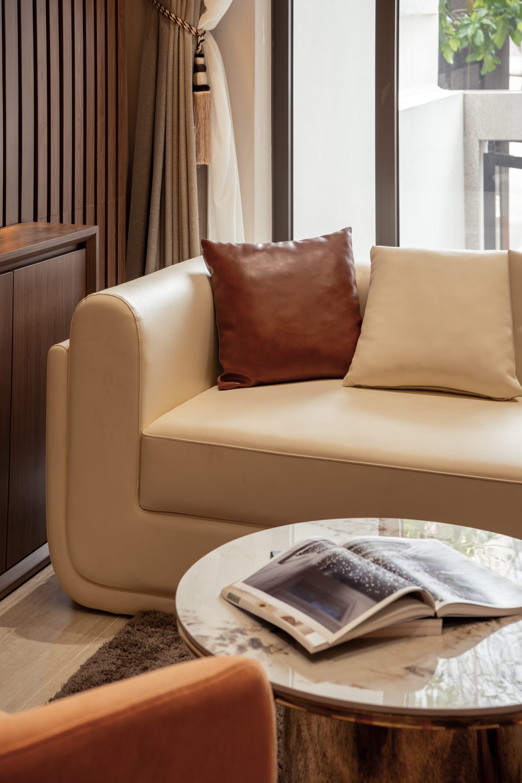 Ghế sofa kem với gối tựa da nâu trong nhà phố Bình Dương