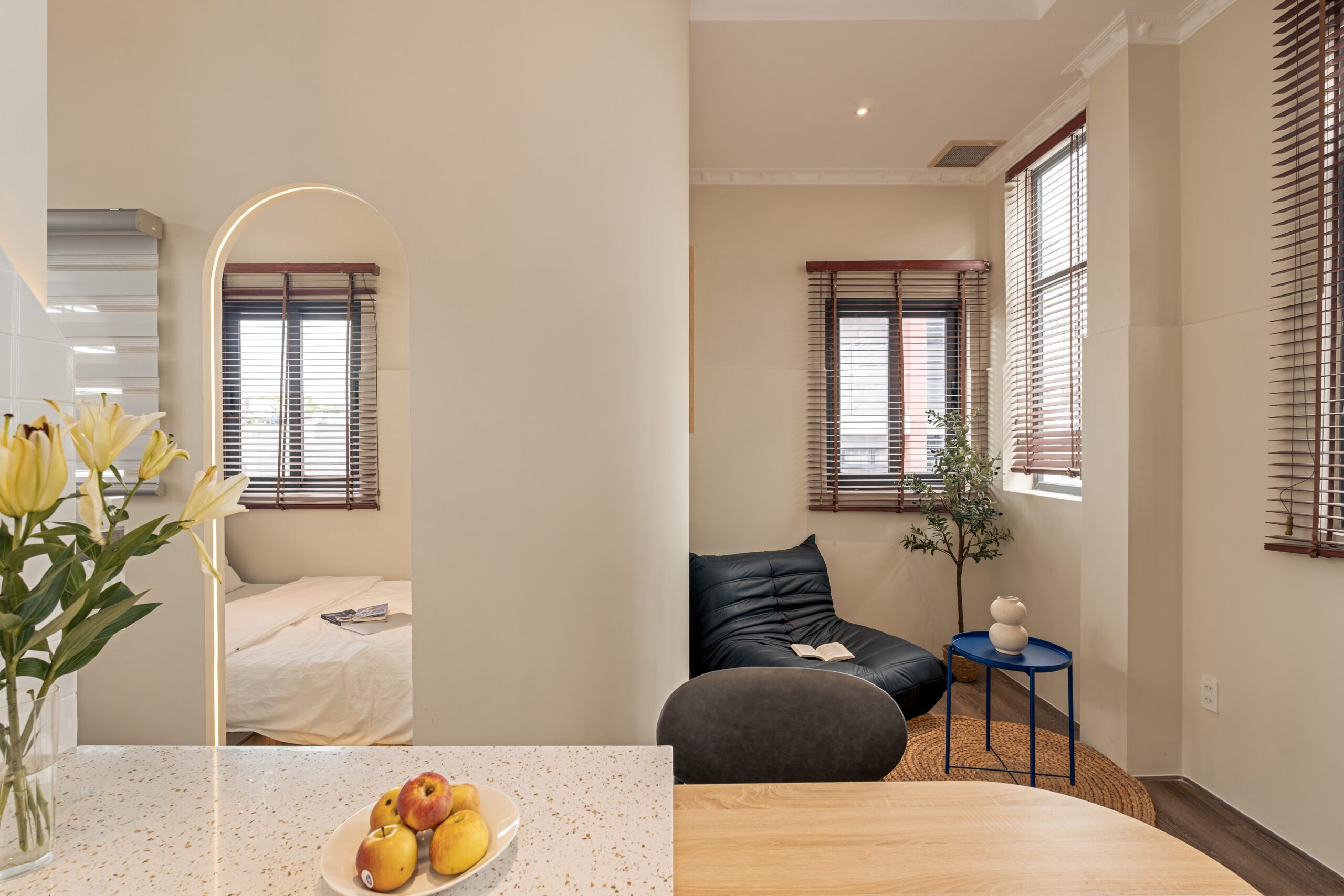 Phòng khách Paar Homestay với sofa xám, bàn tròn và rèm sáo gỗ