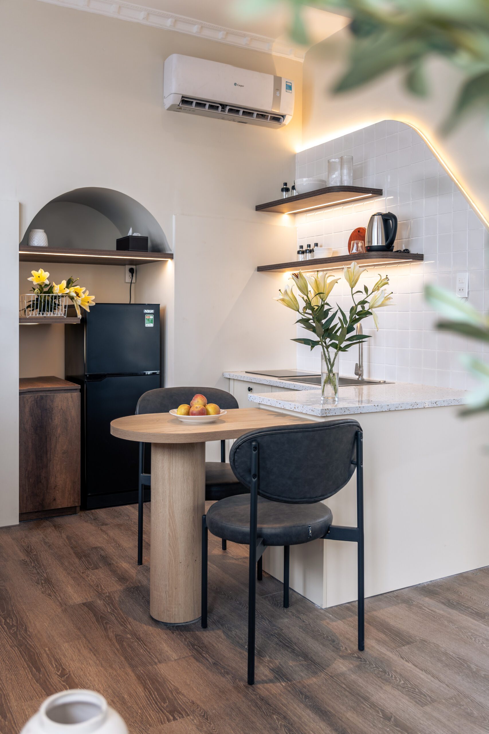Bếp Paar Homestay với tủ lạnh, bàn ăn tròn và ghế bar