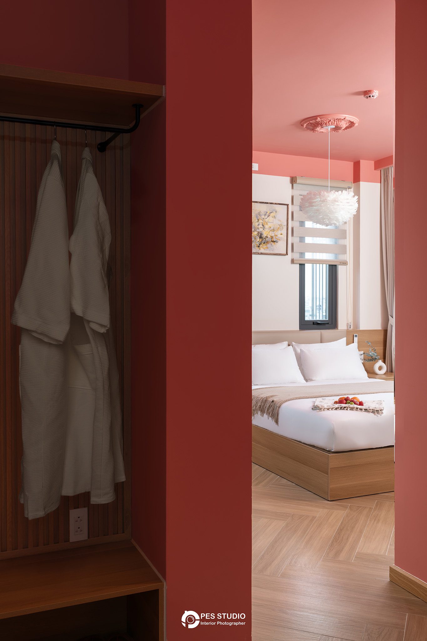 Phòng nghỉ Lumi Riverside với tường đầu giường đỏ và rèm vải