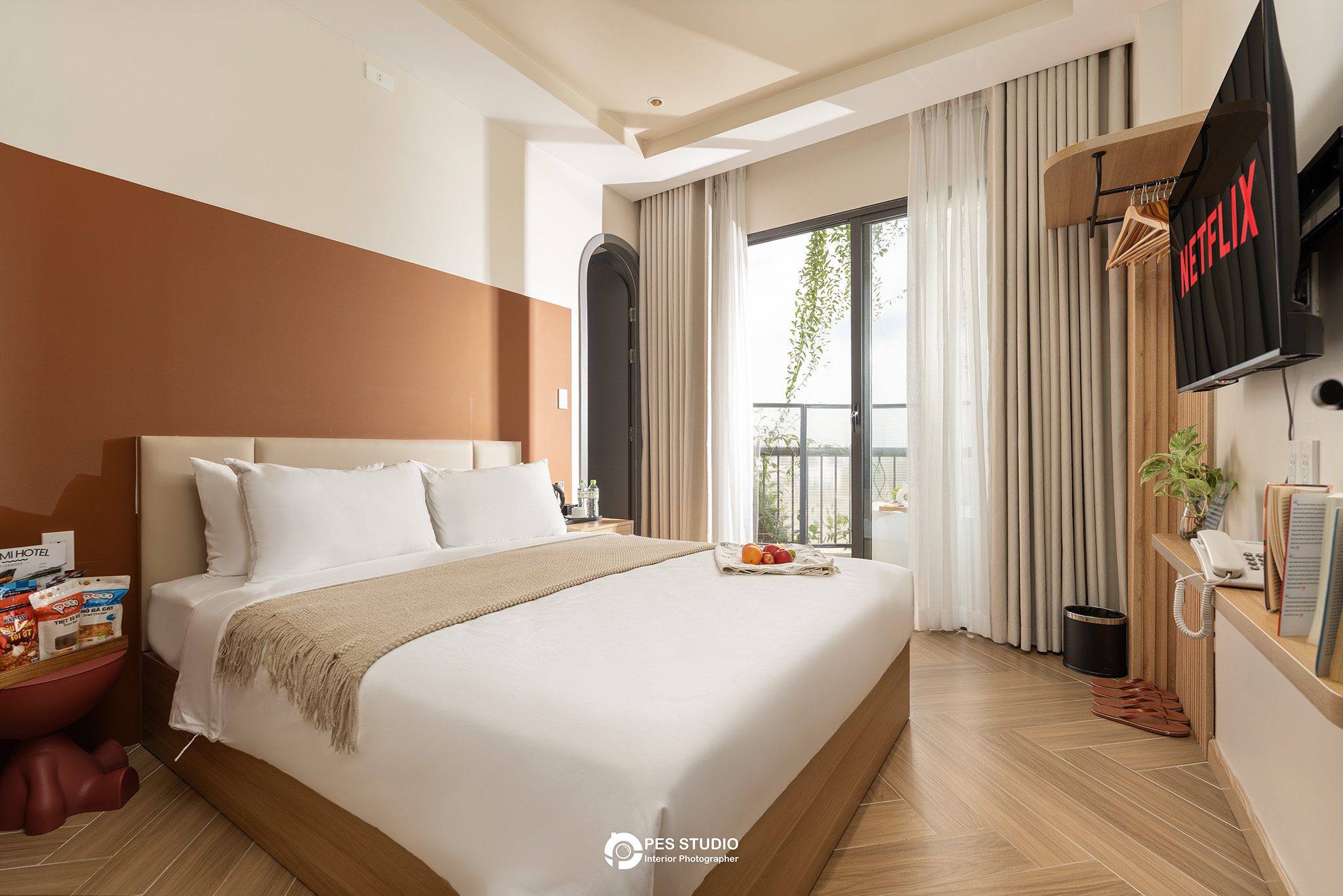 Phòng nghỉ Lumi Riverside với tường ốp nâu và khăn gấp trên giường