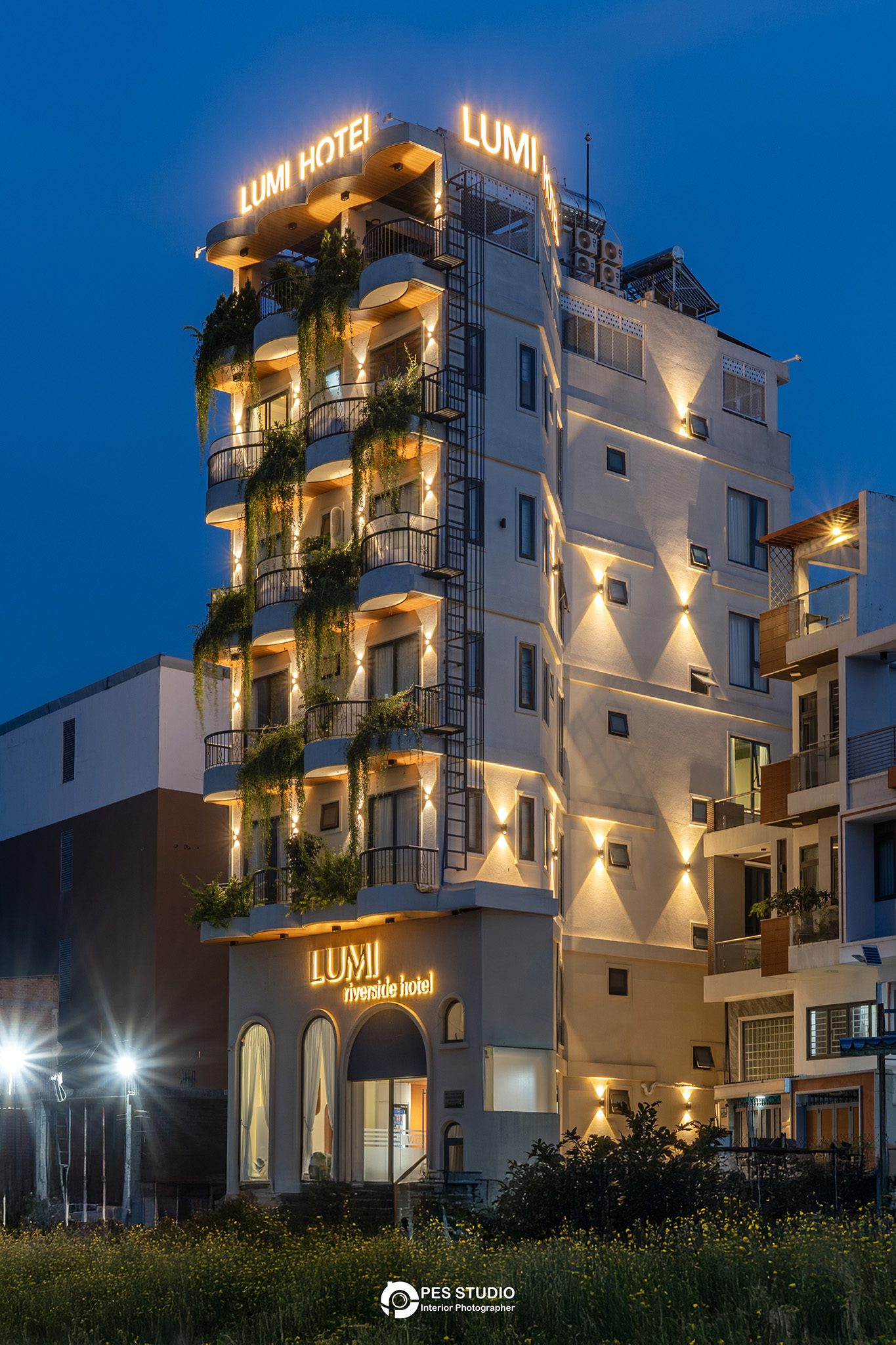 Khách sạn Lumi Riverside chụp chếch từ đầu phố lúc trời chạng vạng