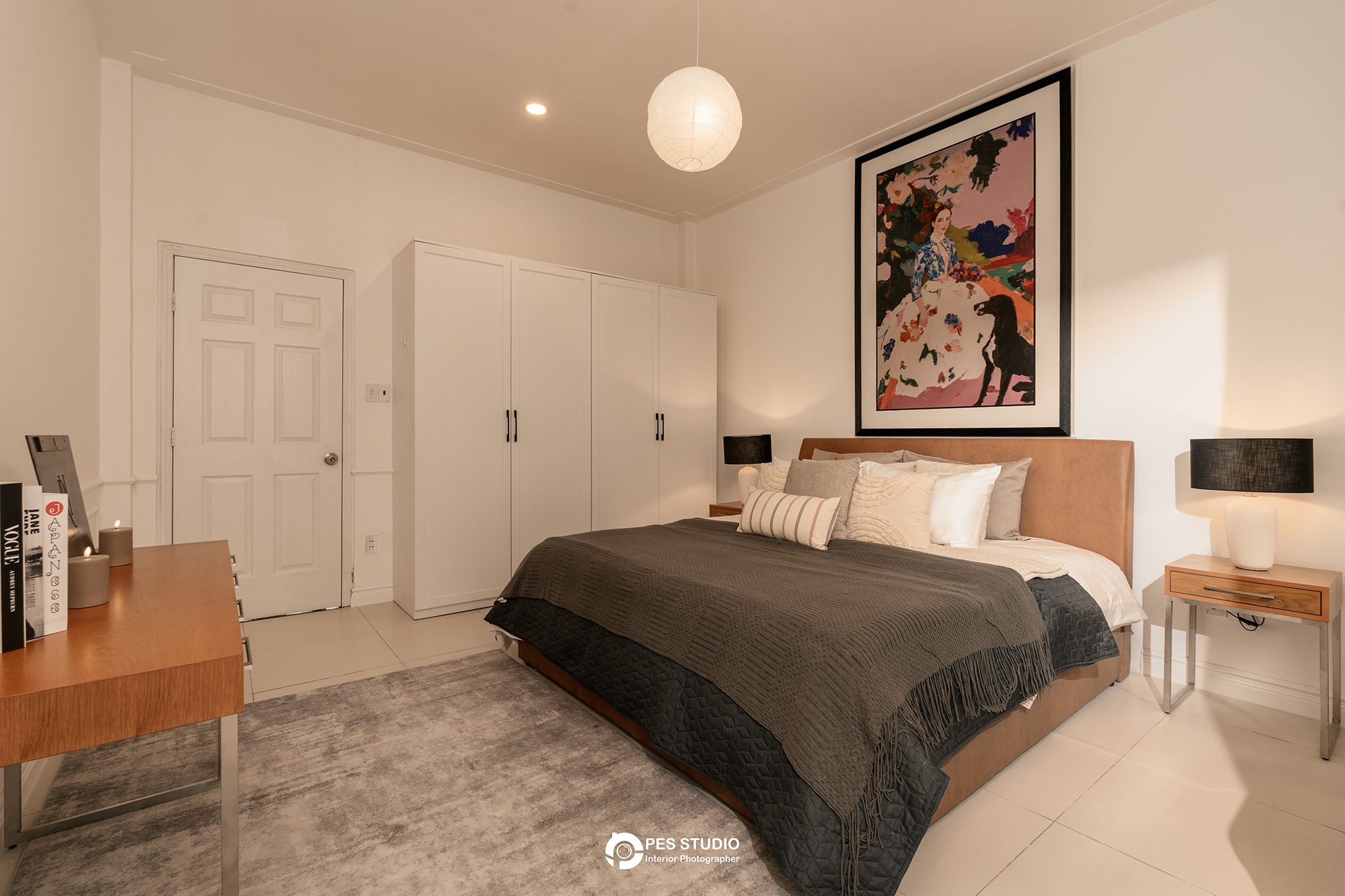Phòng ngủ villa An Phú Compound với chăn nâu và tranh chân dung treo tường