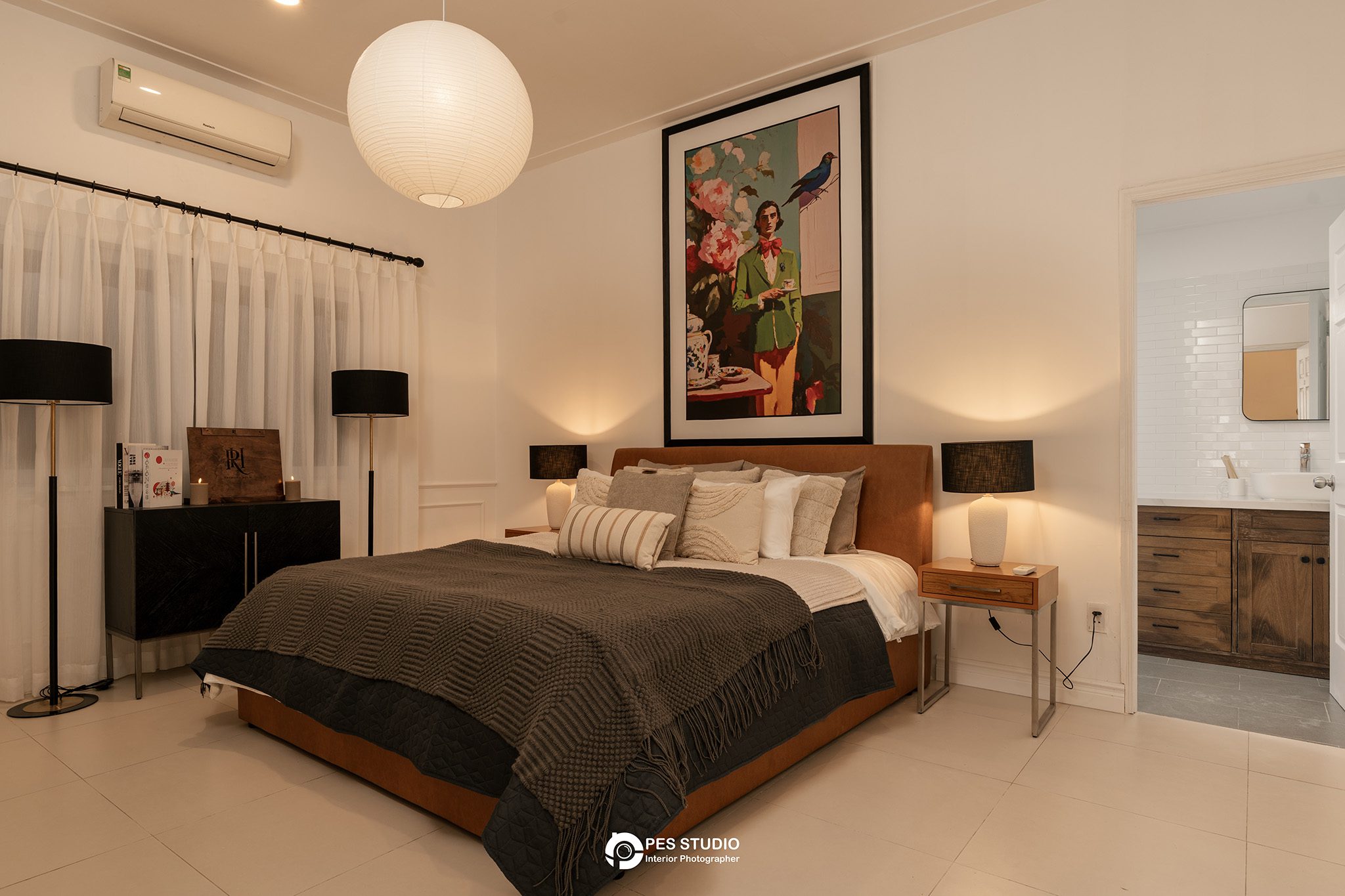 Phòng ngủ villa An Phú Compound với chăn nâu sẫm và cửa sổ chớp gỗ