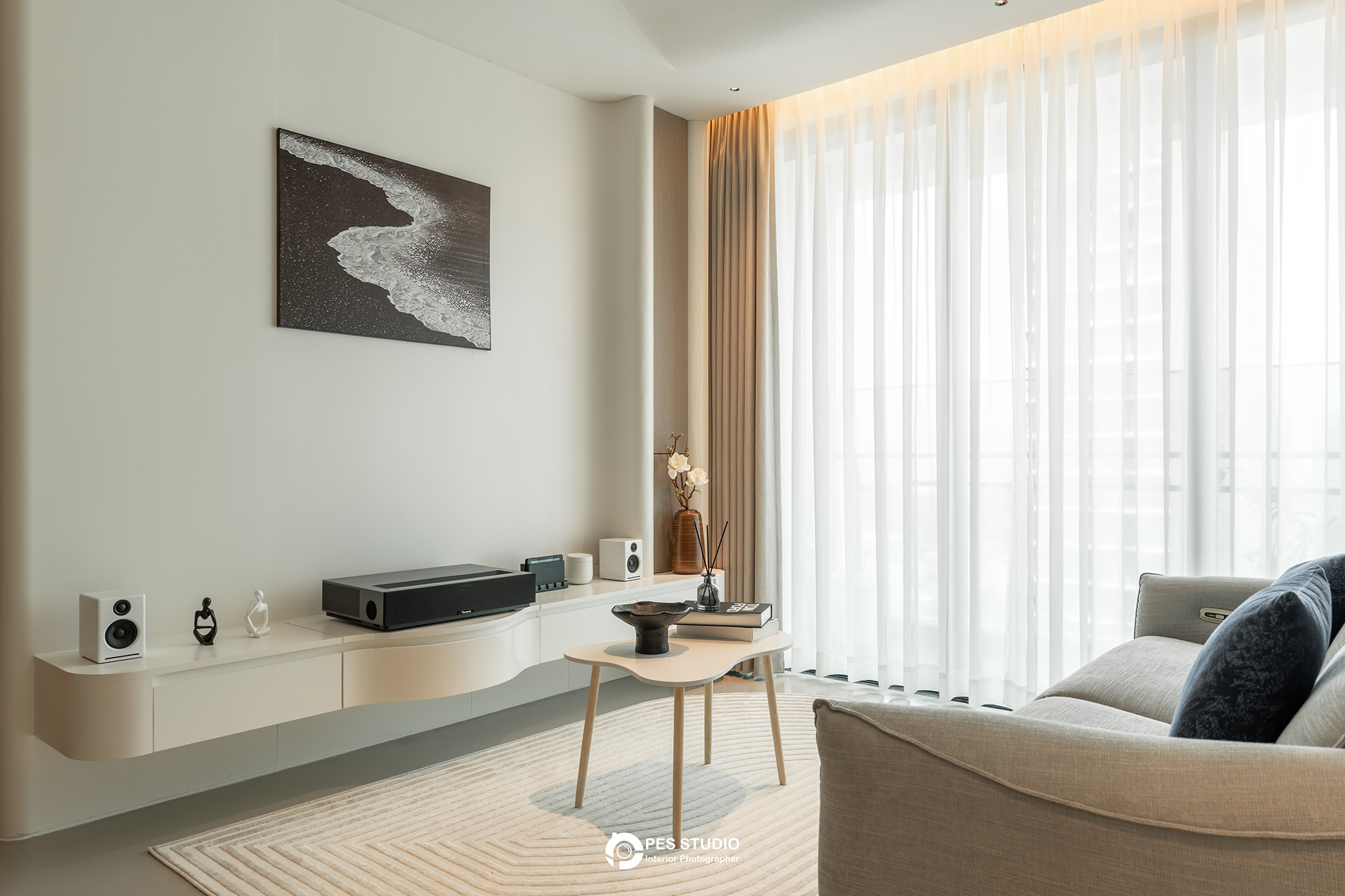 Phòng khách căn hộ Feliz En Vista nhìn ra ban công qua rèm voan