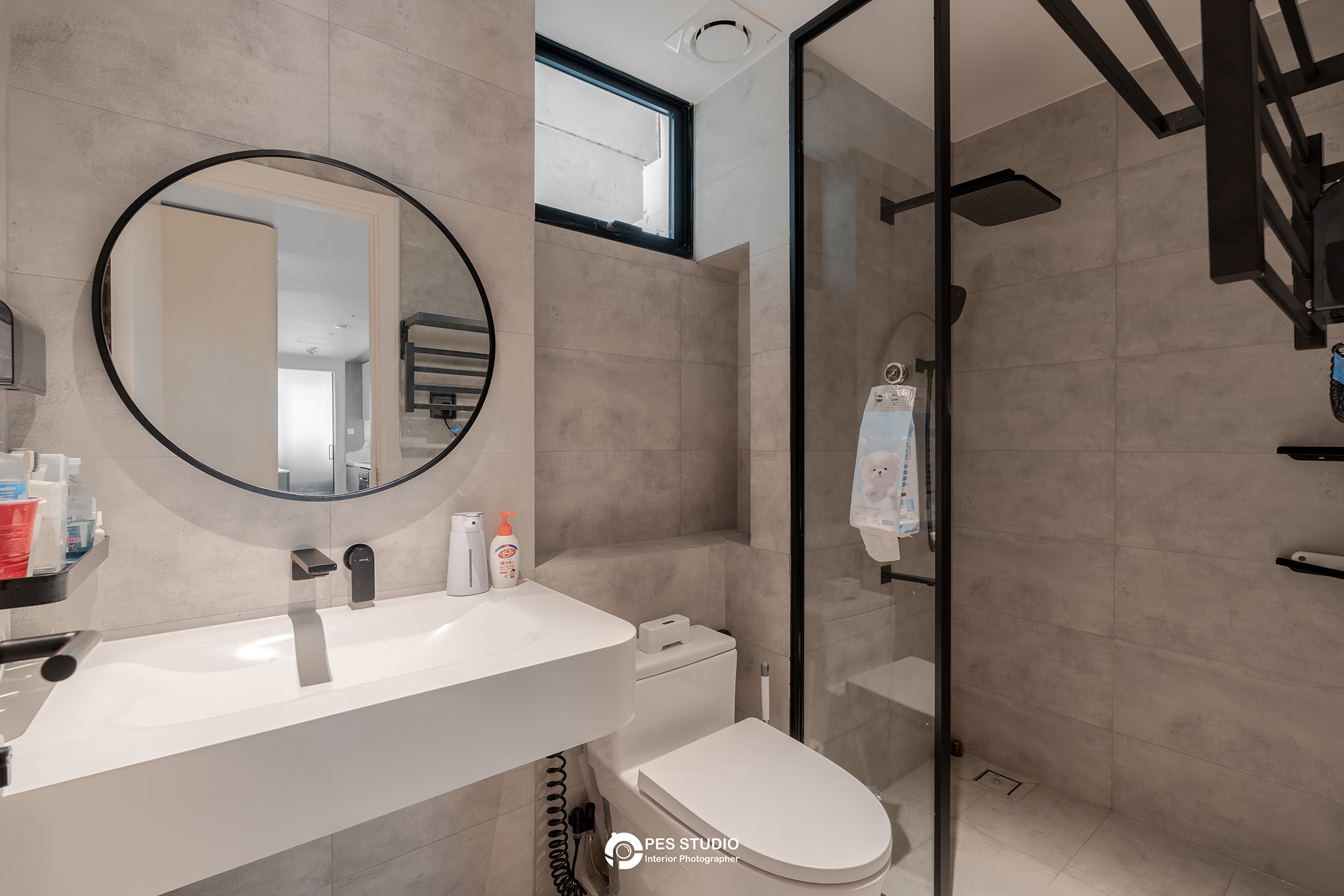 Bàn lavabo dài với gương tròn viền đen trong căn hộ Feliz En Vista