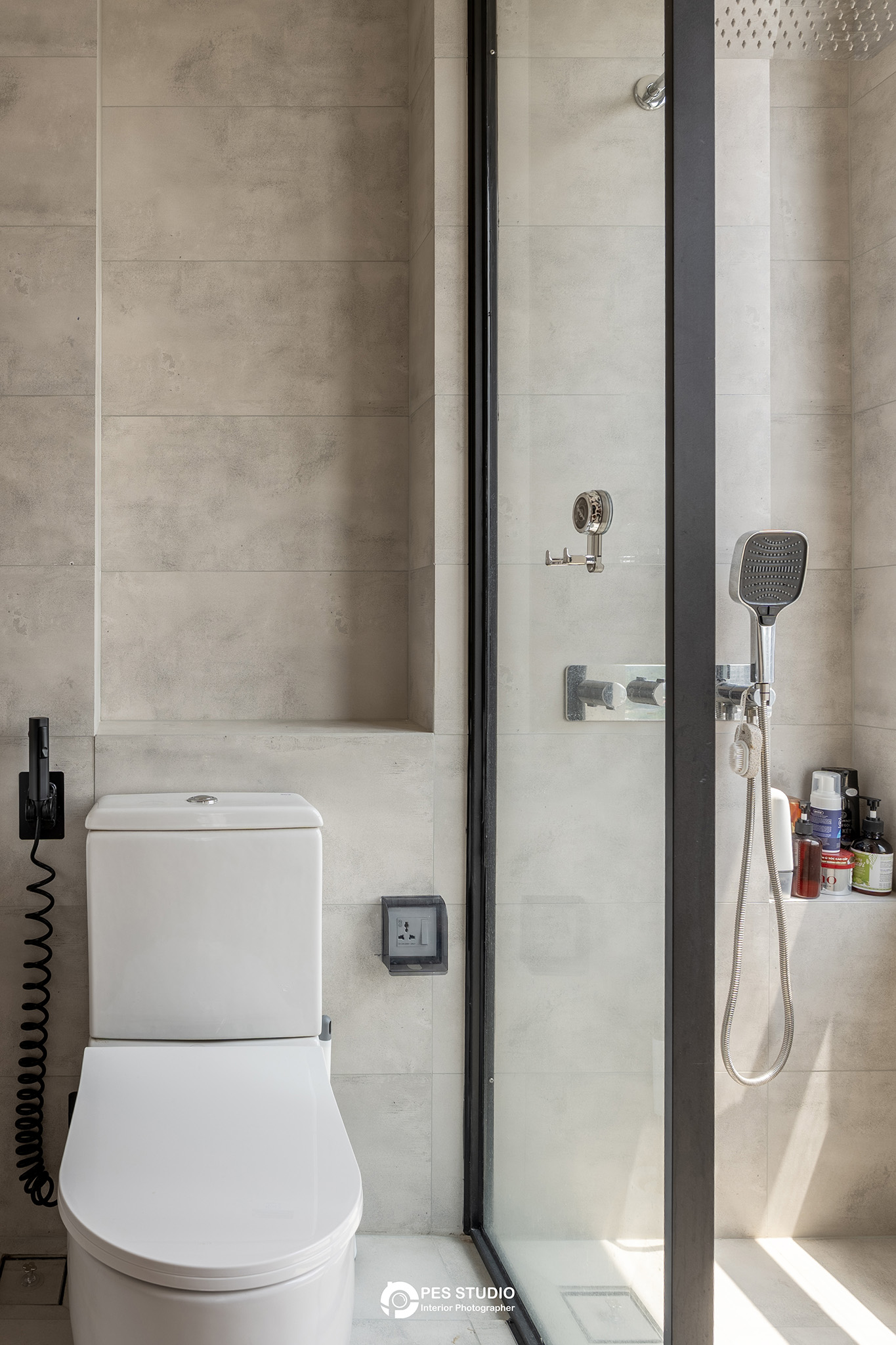 Buồng tắm đứng ốp đá với sen tắm đen trong căn hộ Feliz En Vista