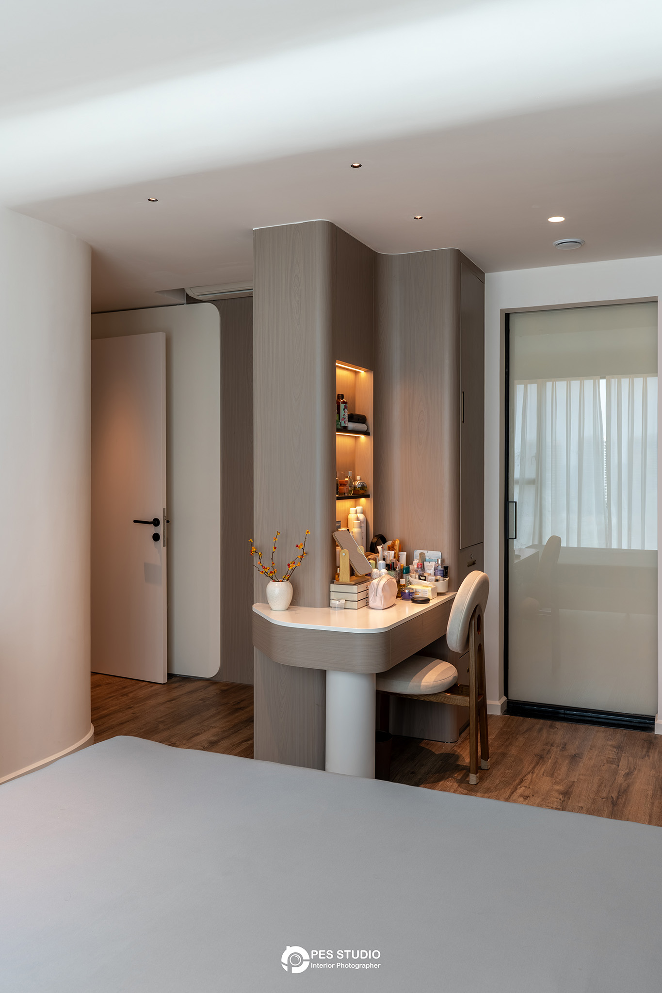 Góc phòng ngủ với bàn tròn nhỏ và cửa kính trong căn hộ Feliz En Vista