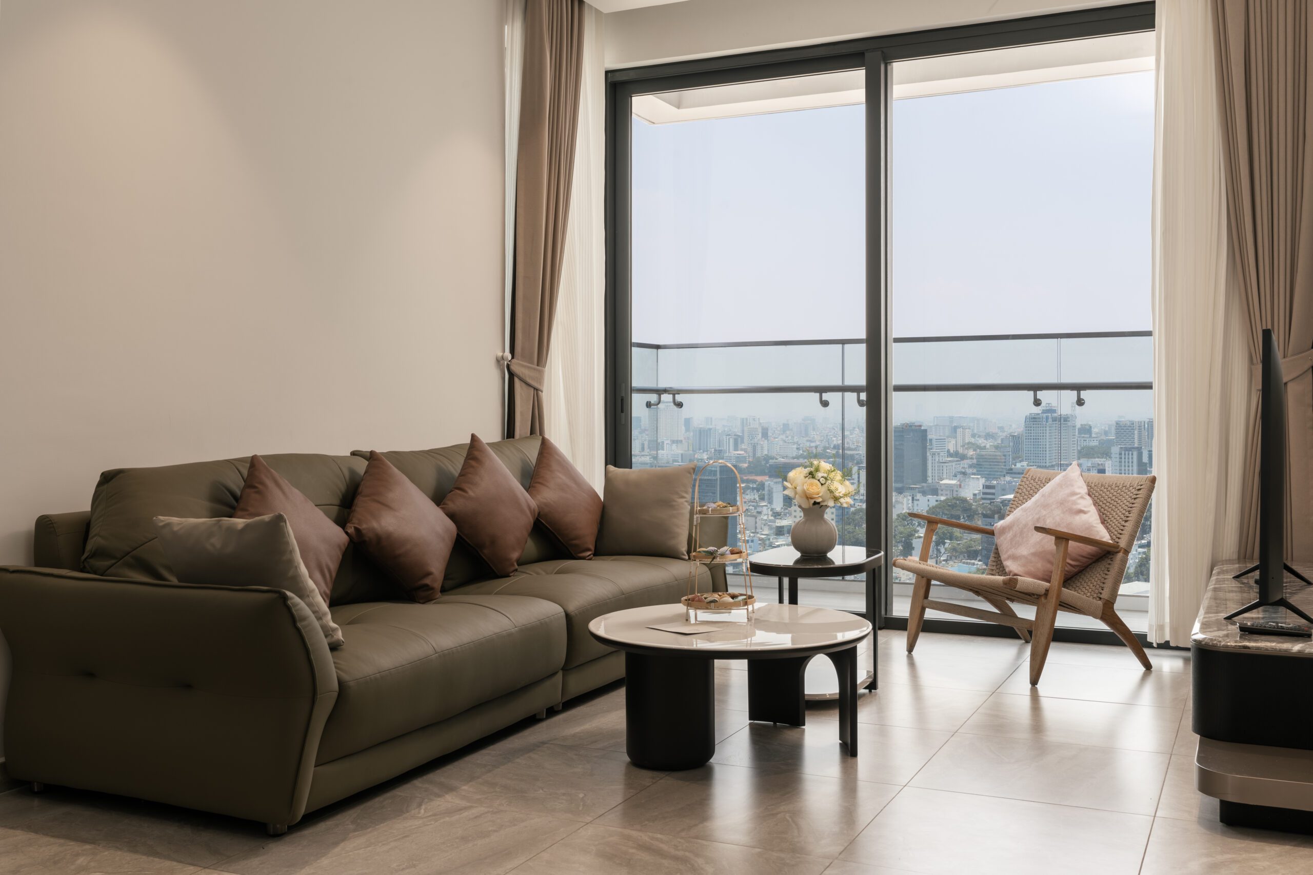 Phòng khách căn hộ Lancaster Legacy với sofa và cửa kính nhìn ra sông