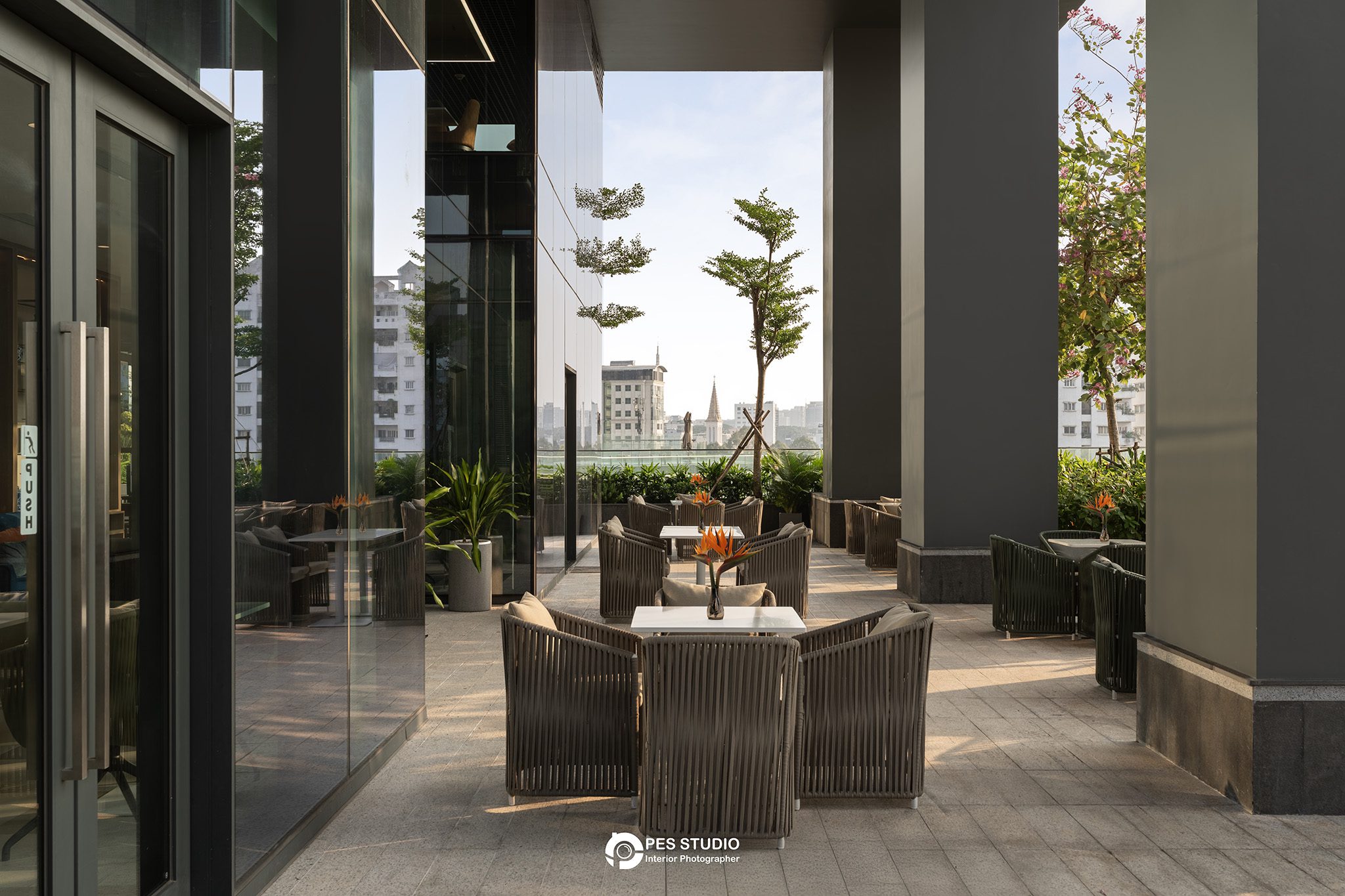 Khu ngồi ngoài trời Lancaster Legacy Tower giữa hàng cột và cây xanh
